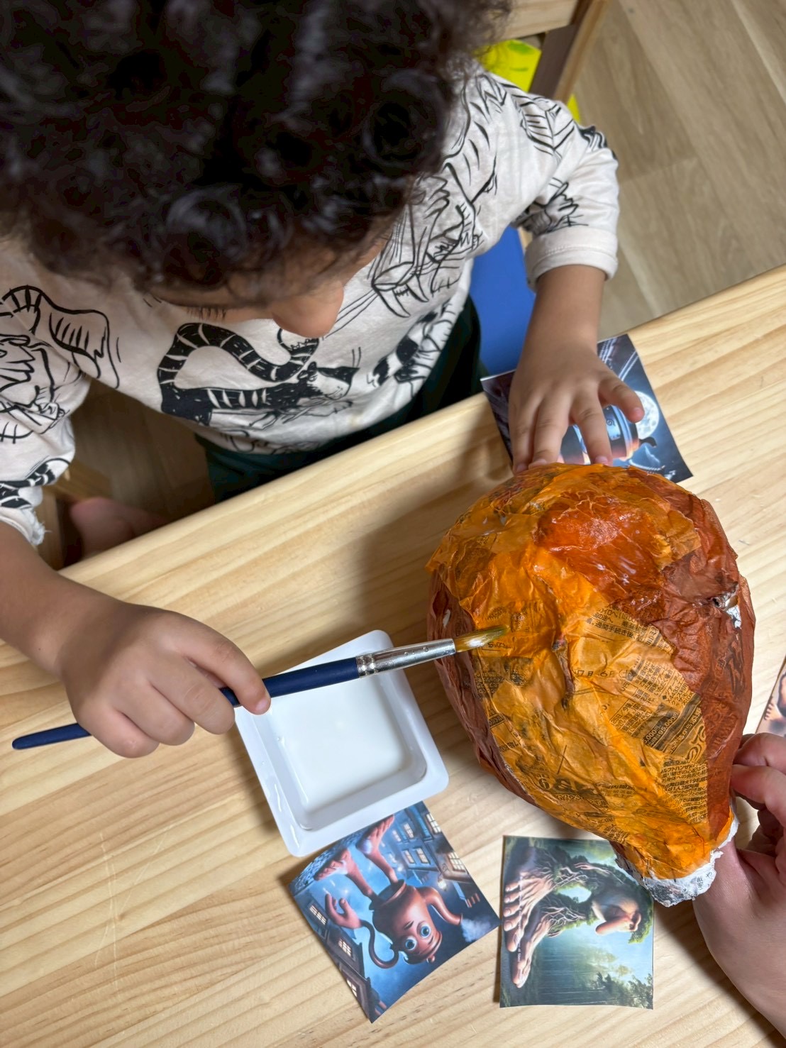 「絶対に成功させるぞ!」と熱意を持って、風船に新聞紙を何層も糊付けするピニャータ制作中の子どもたちの手元