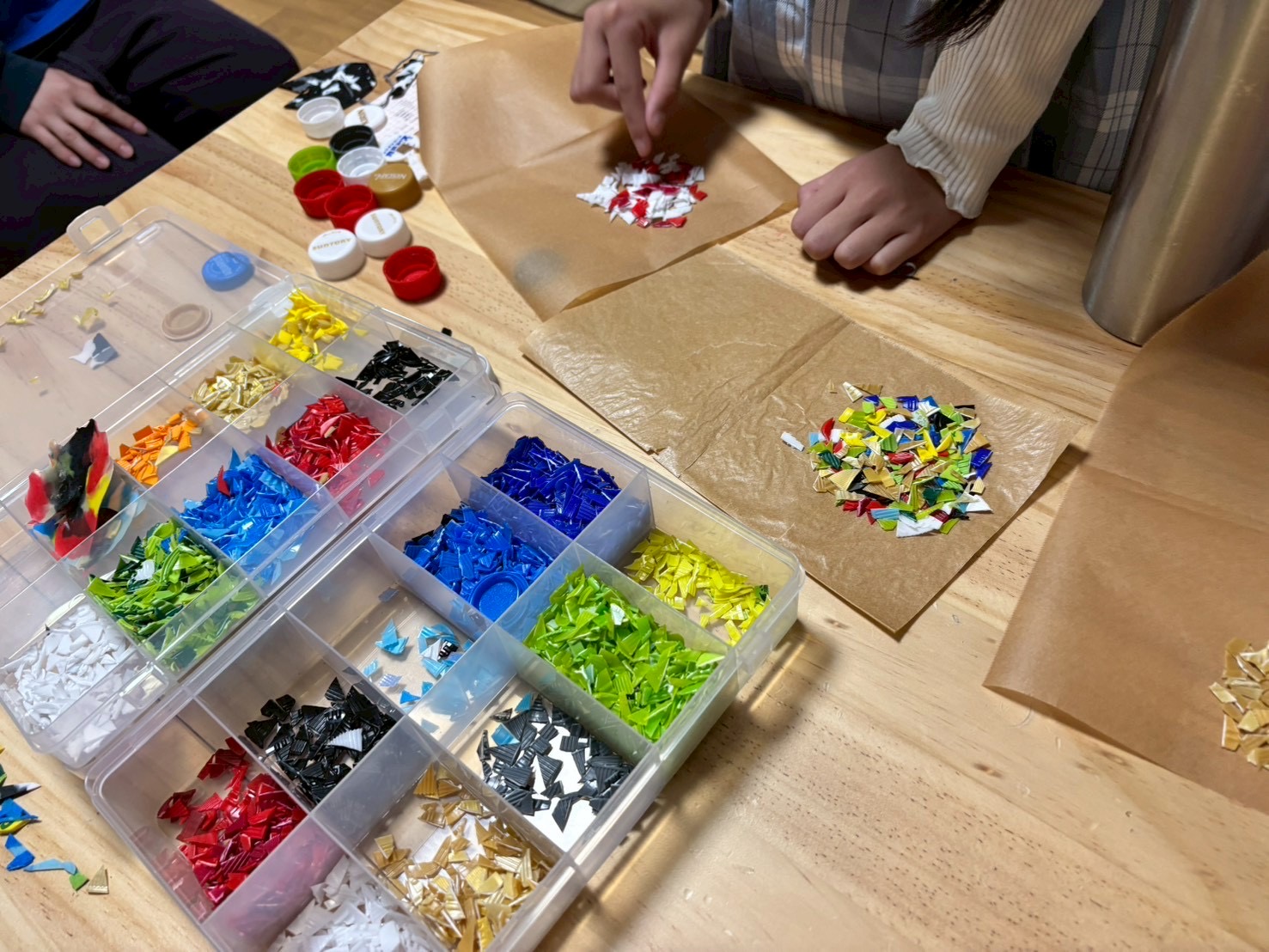 ペットボトルやモール、ビーズなどの廃材を使い、思い思いのアイデアを形にする創作活動の様子
