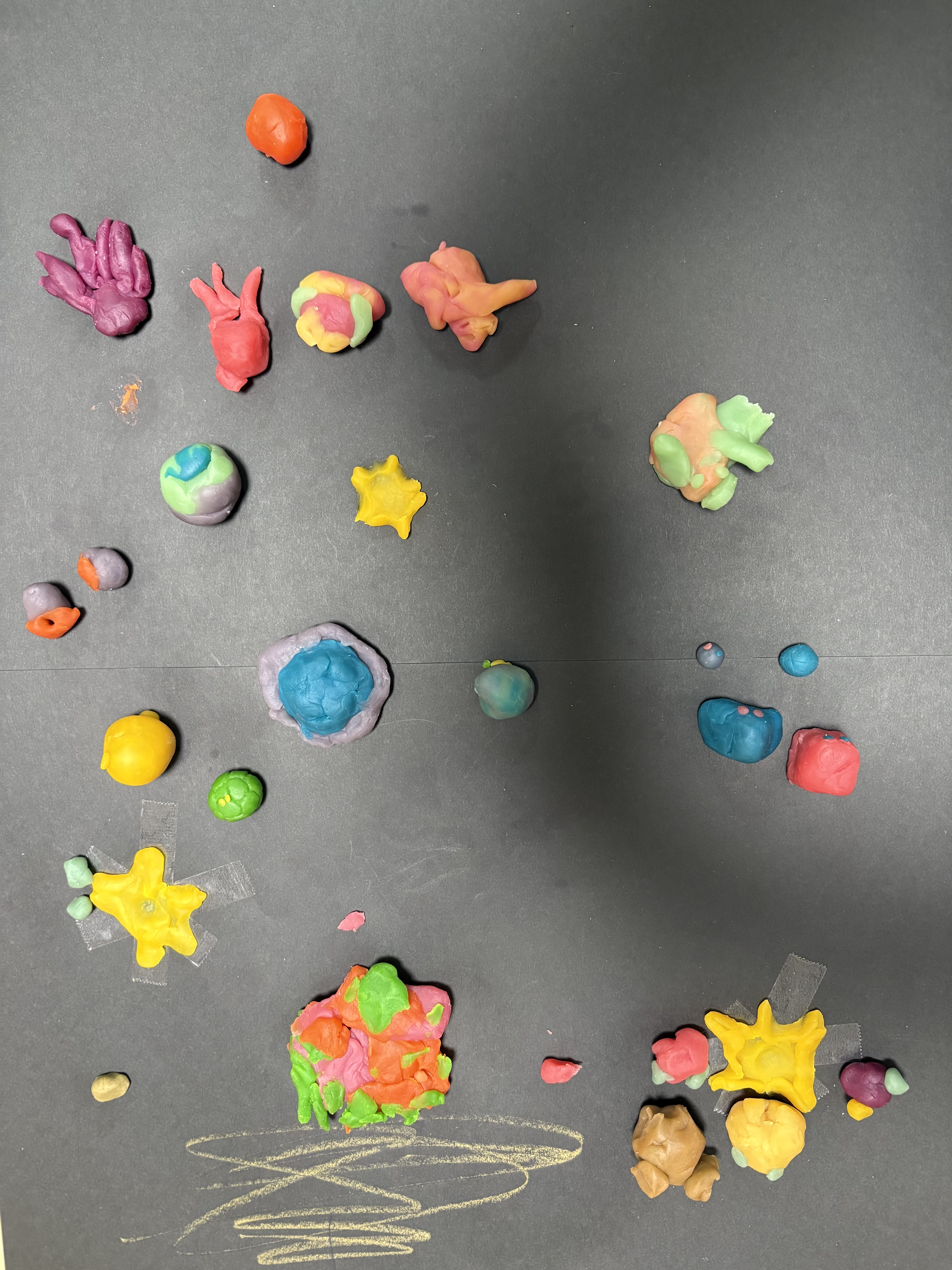 子どもたちが作り上げた、色とりどりな宇宙人の作品を並べて展示した様子
