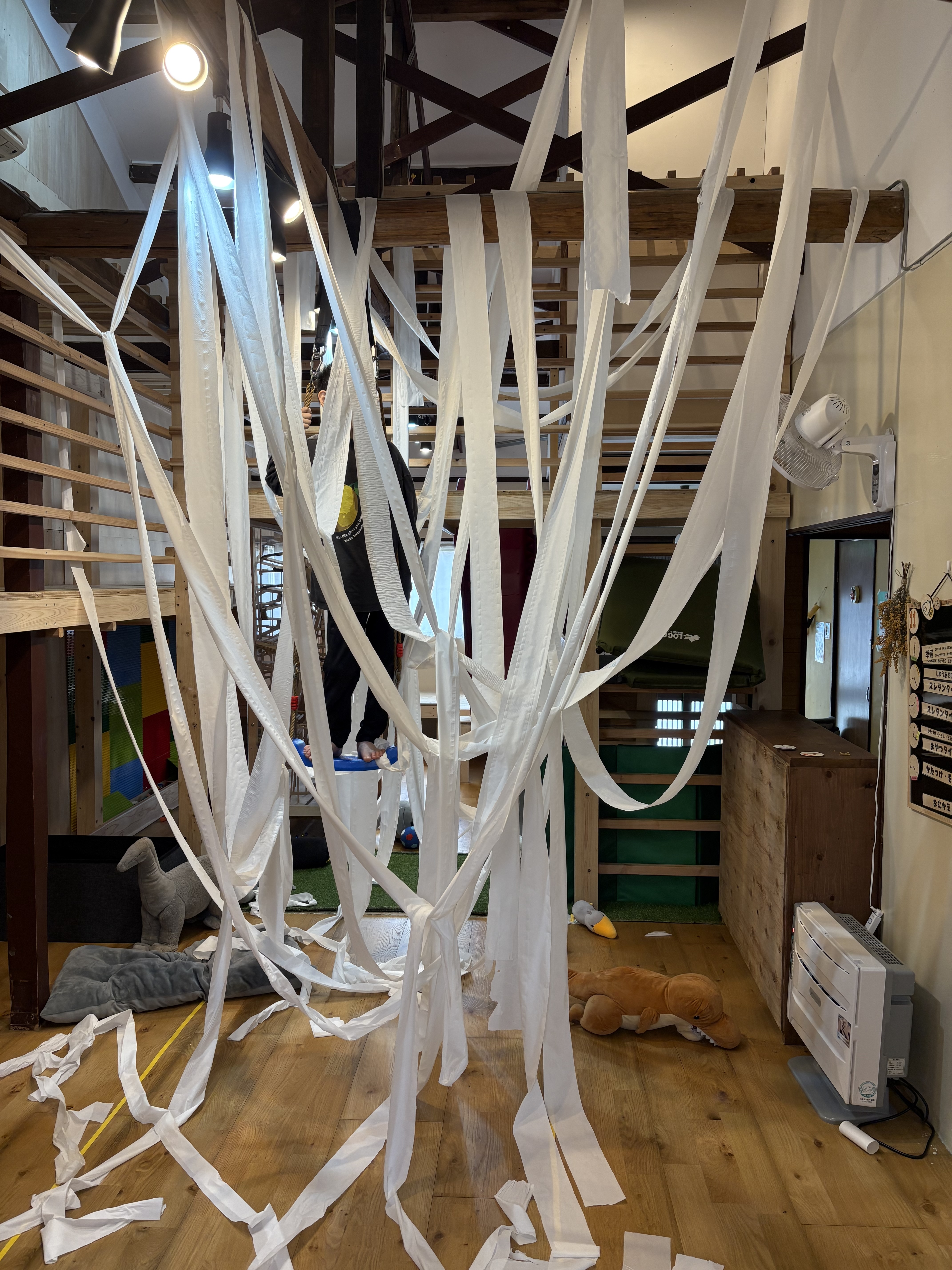 高い梁と吹抜け、大型木工遊具がある、心と体が解放されるスレタンハウスのダイナミックな室内空間
