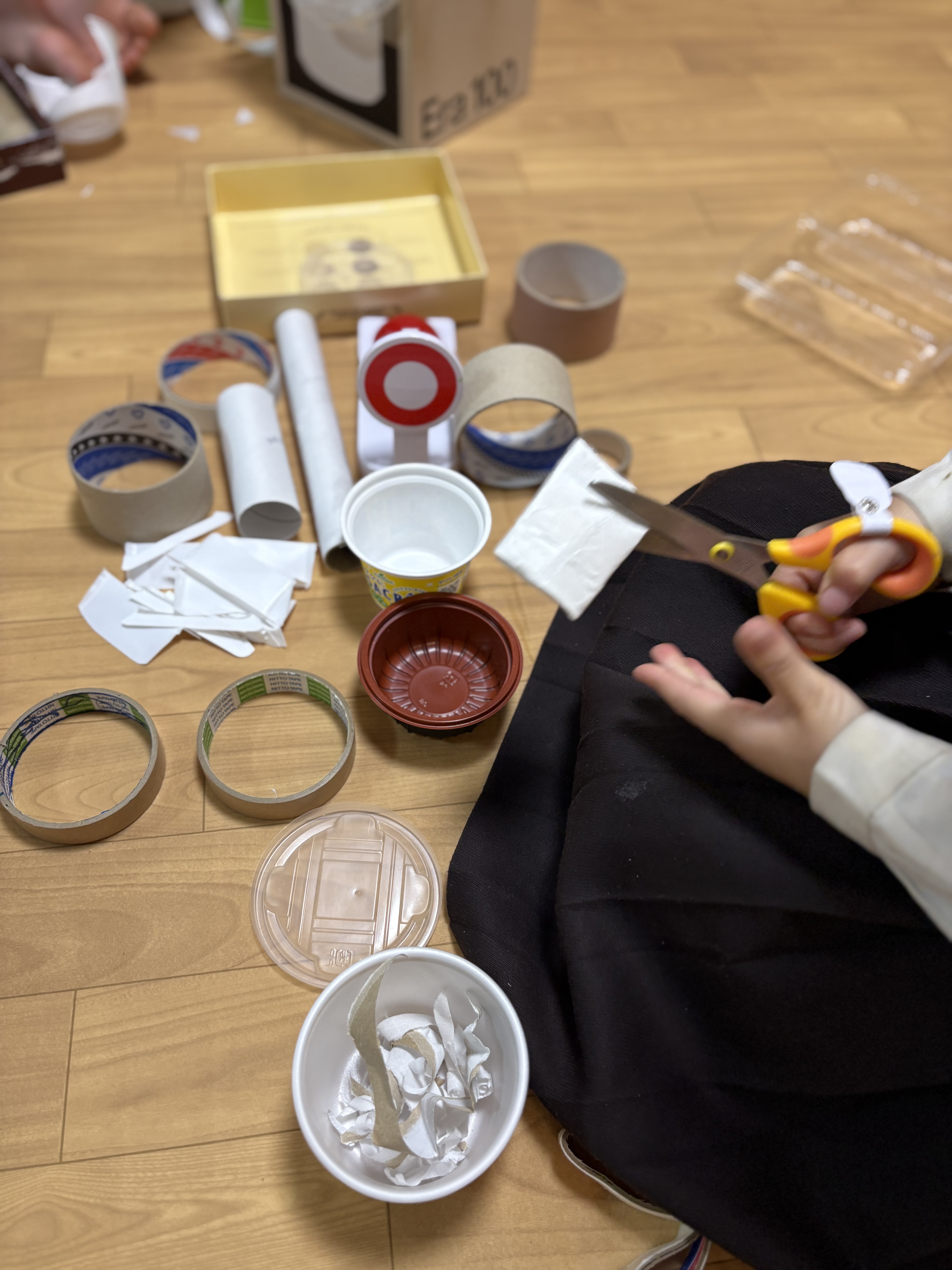 真剣な表情で、紙や素材を使って究極のお弁当作りに没頭する子どもたちの手元
