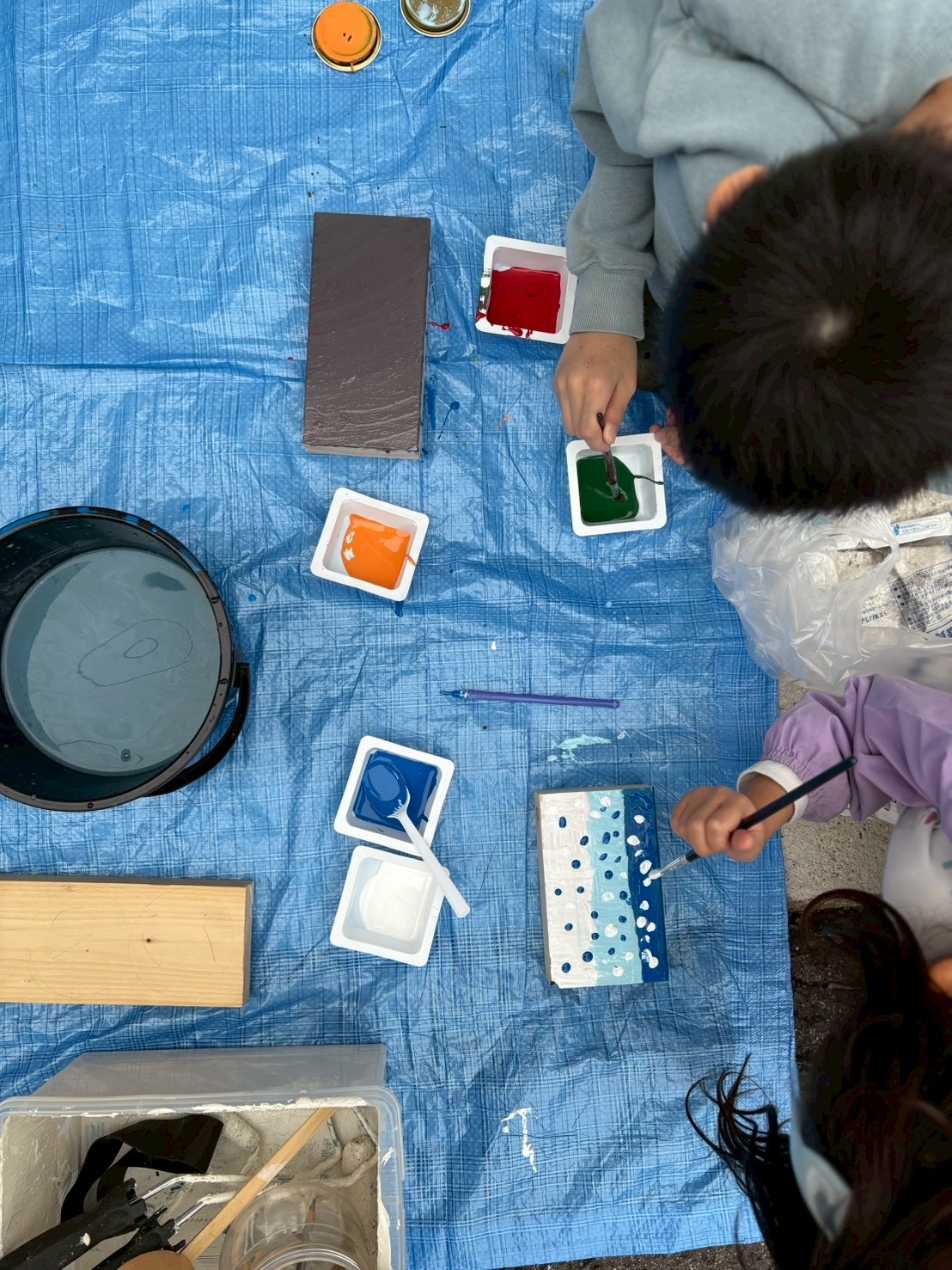 「気持ちいい！」と感触を楽しみながら、木材に好きな色を重ねていく様子
