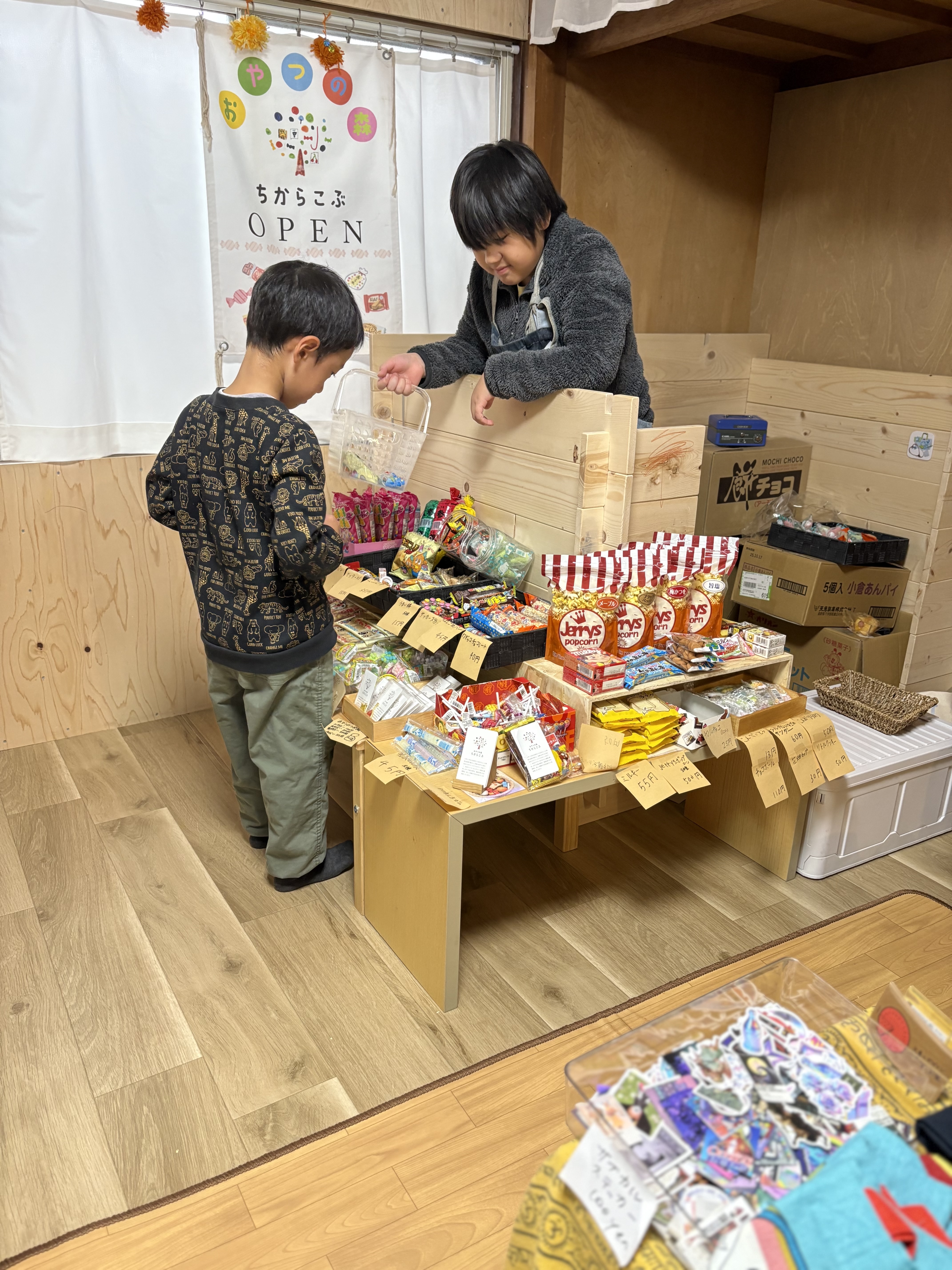 おやつの森　ちからこぶでお買い物中。いっぱいあってどれにしようか迷い中の子ども