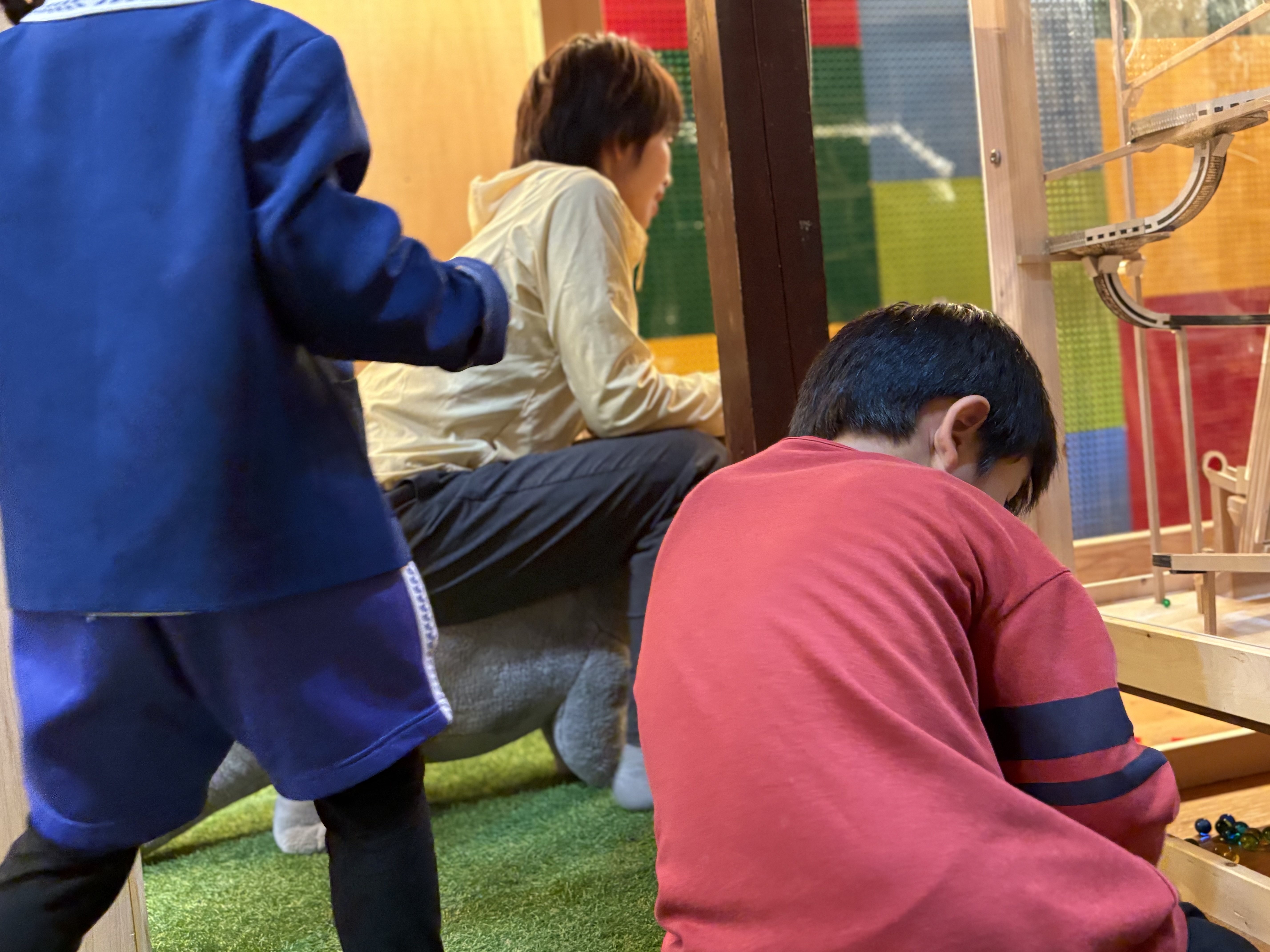 遊びもそれぞれ違って良し。ビー玉遊びをする男の子。