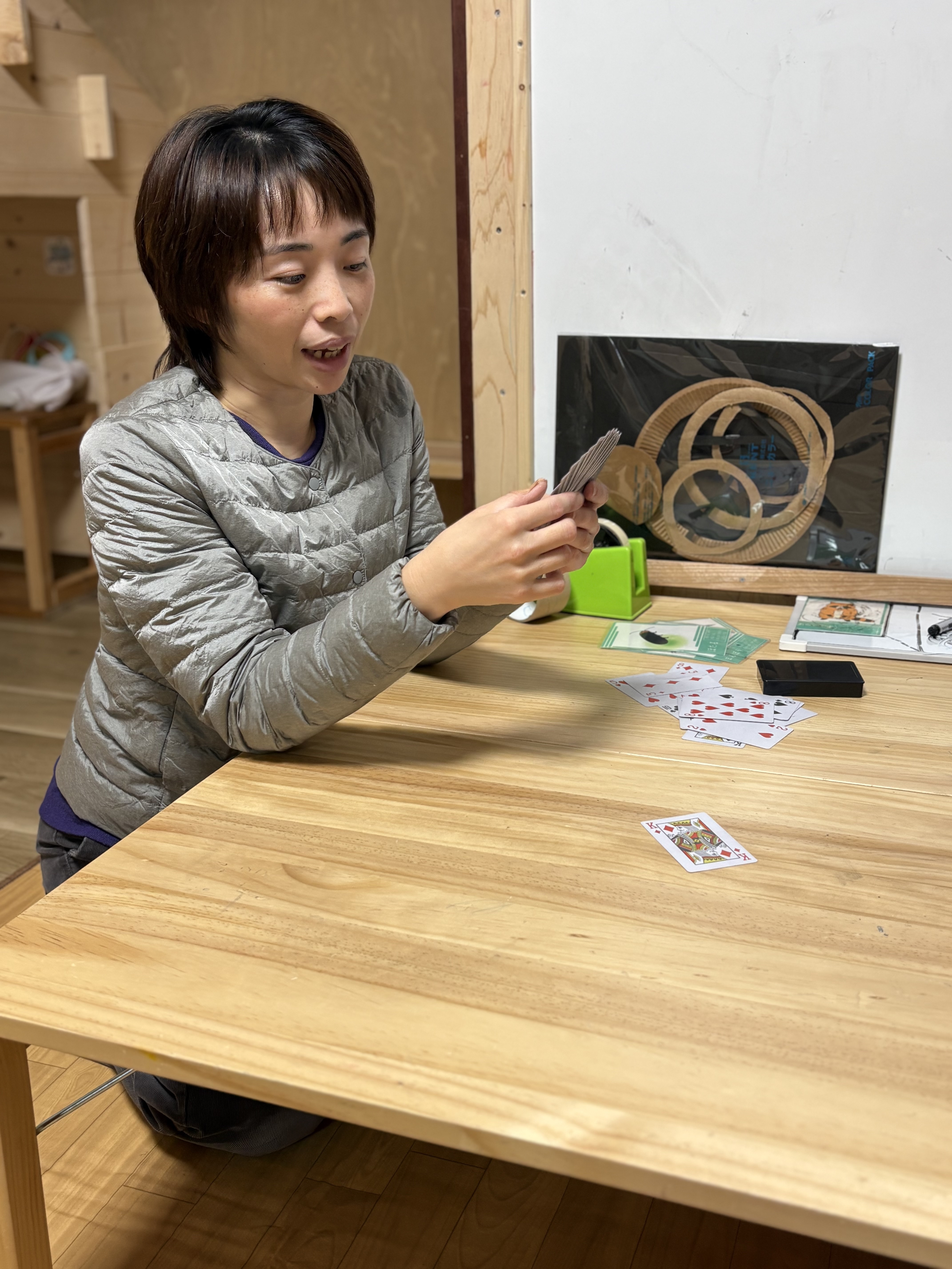 相手の目線・表情を見て、スタッフとトランプをしている。