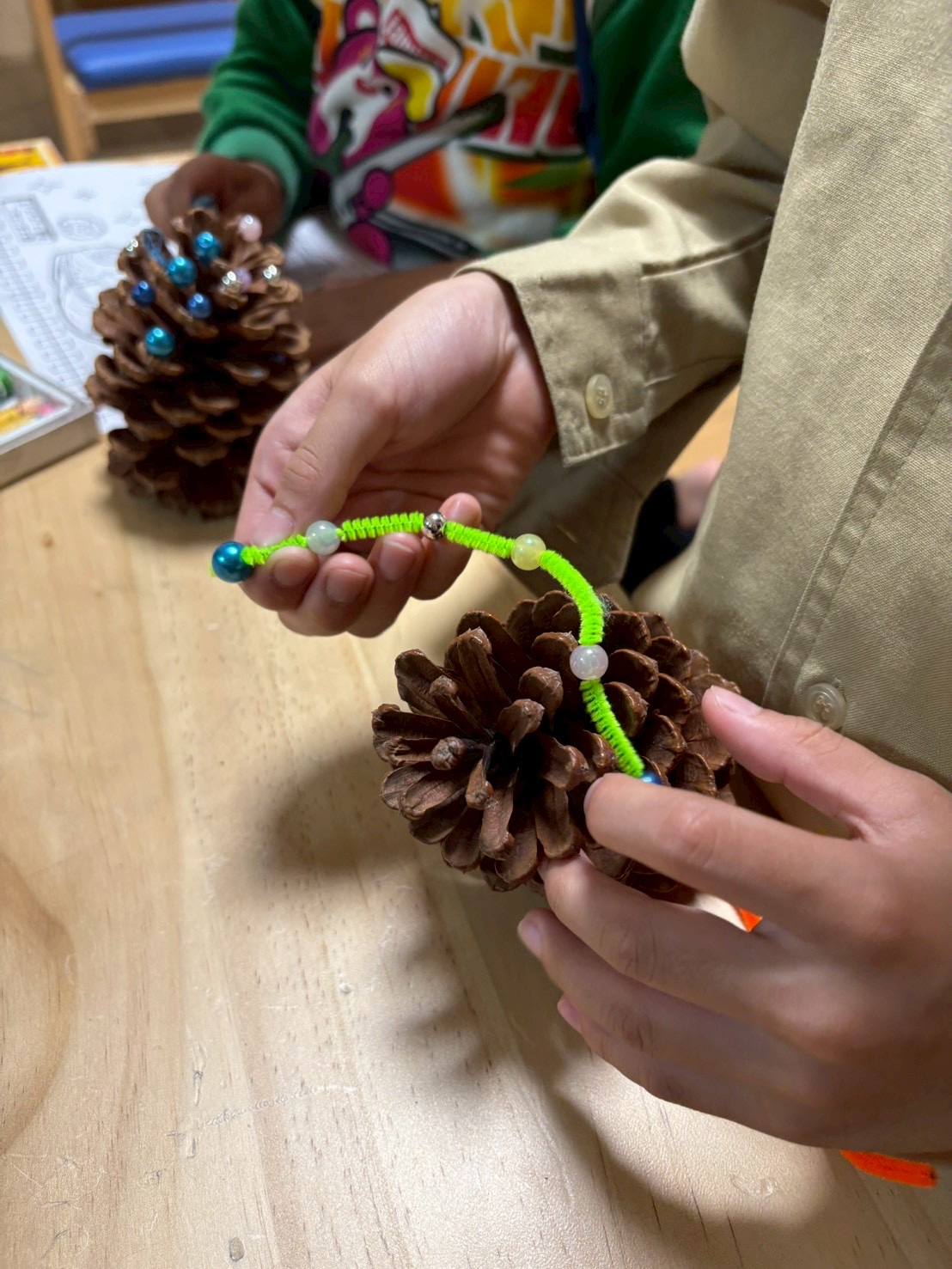 スタッフが「〇〇くんが塗った緑、森みたいでカッコいいね！」と共感し、子どもの頑張りを言語化して自己肯定感を育む瞬間