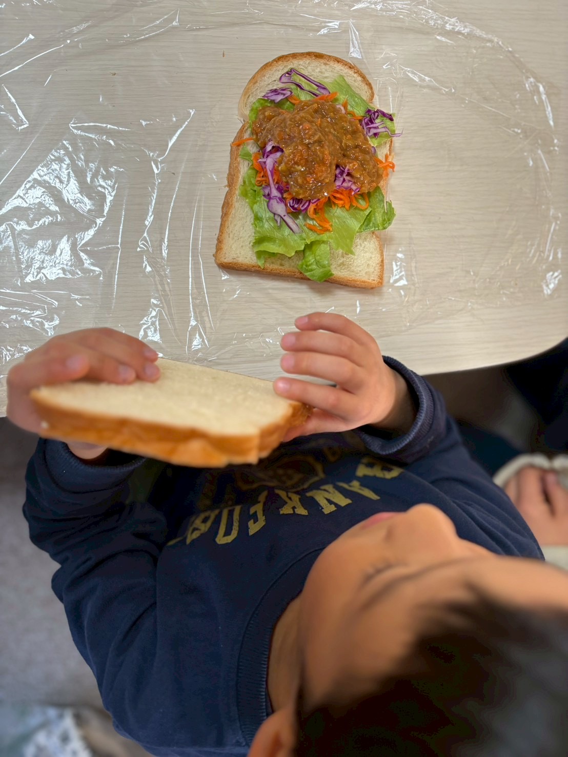 あとはパンを重ねたら出来上がりだ。
もう少しで食べれると思うと嬉しさが笑で漏れてきた子どもたち。
