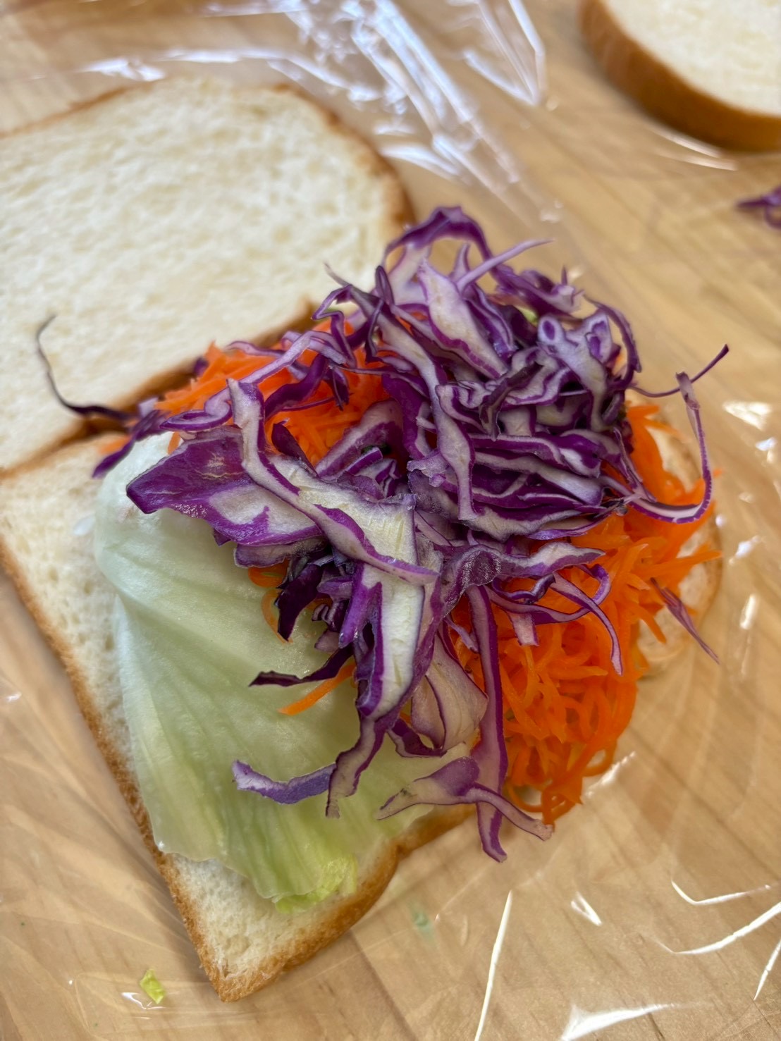 パンから落ちないようにゆっくりと野菜を盛っていく過程。普段は食べない野菜も色鮮や傘にびっくり。