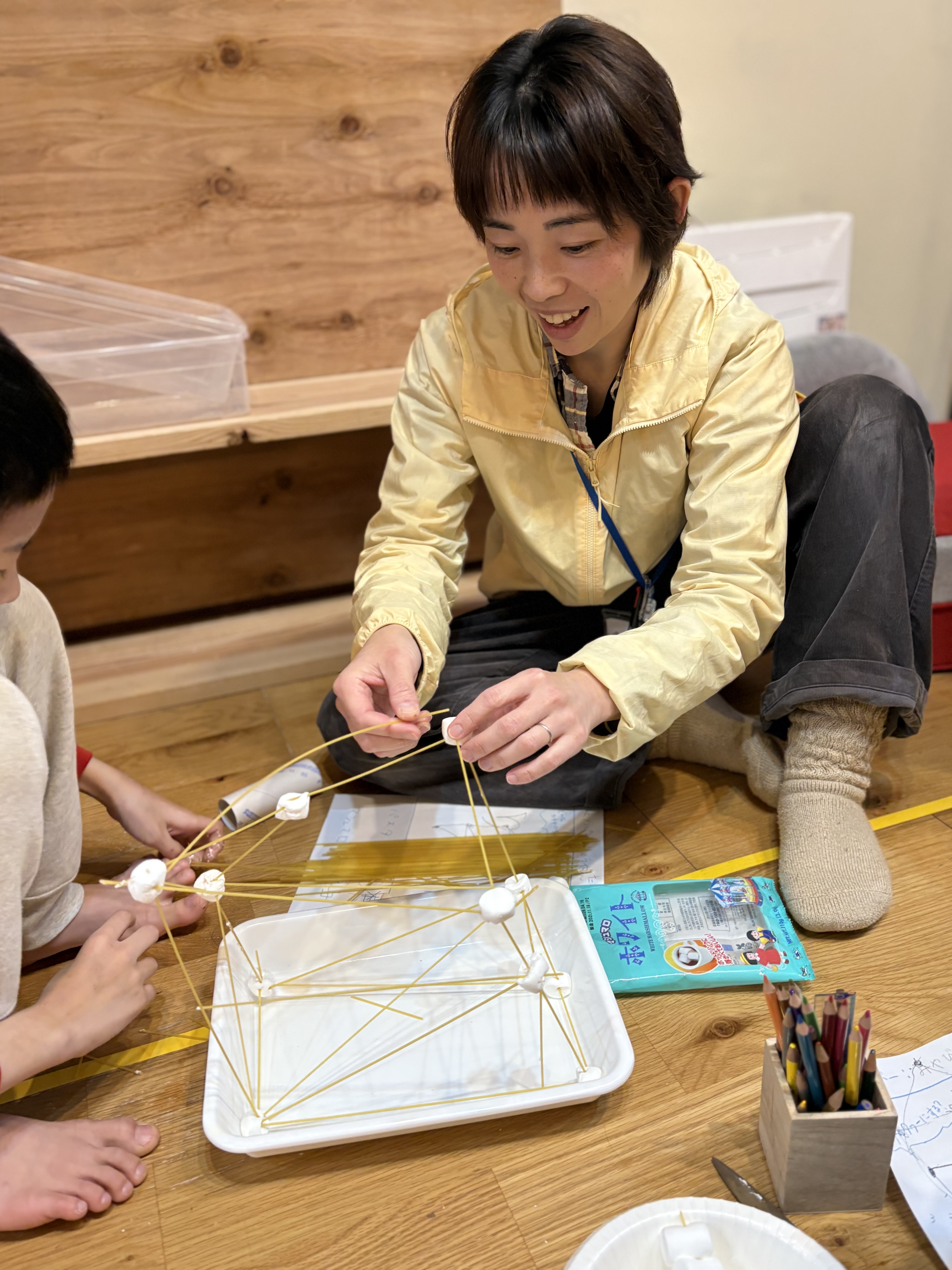 パスタとマシュマロを使い、チームで協力してタワー作りに挑む子どもたち。グループごとに「負けたくない」という熱い空気が漂う