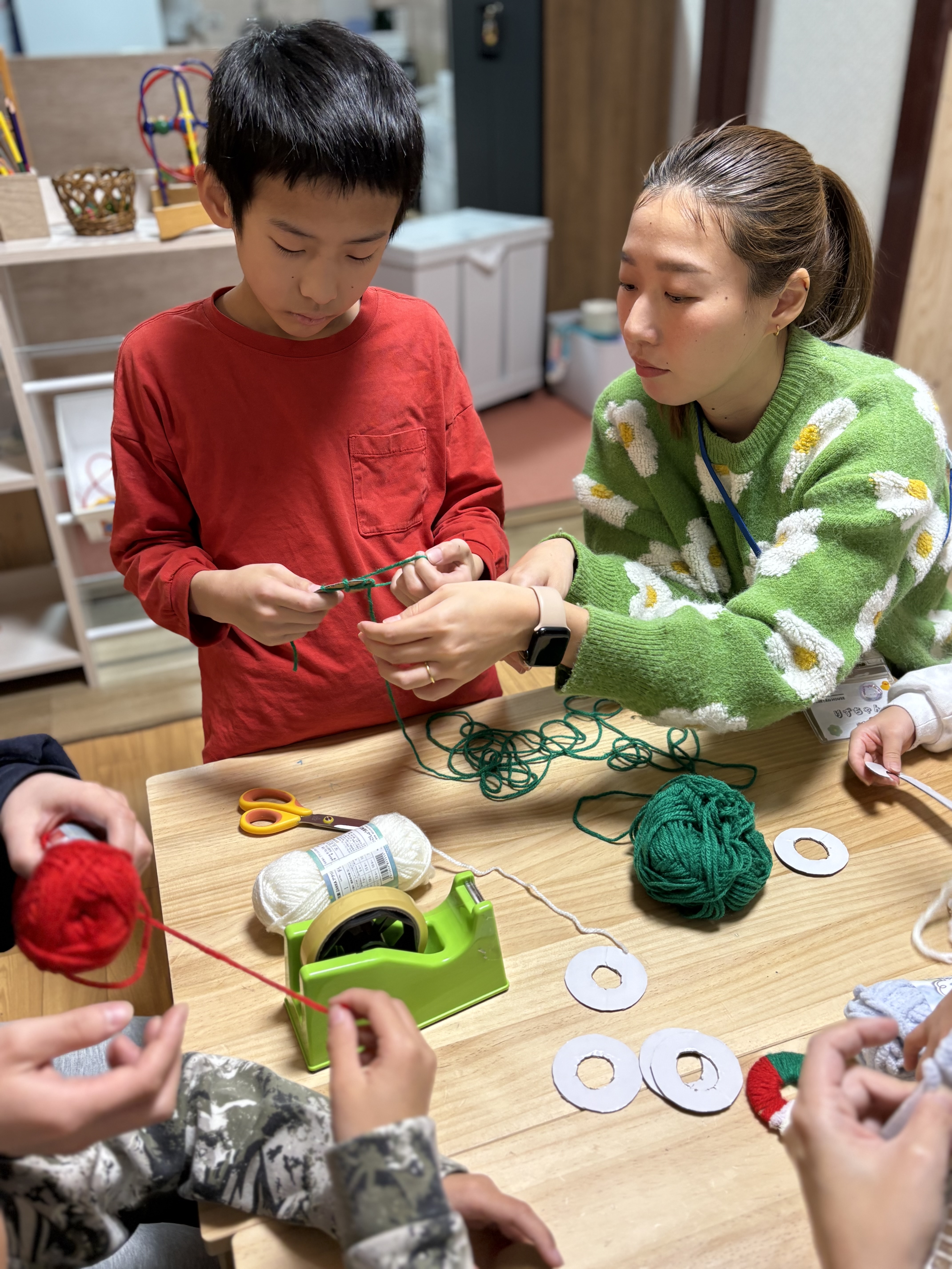 スタッフの遊びのアイデアに引き込まれ、「やりたい！」という意欲を持ってオーナメント作りに挑戦し始めた未就学児のベビーステップ