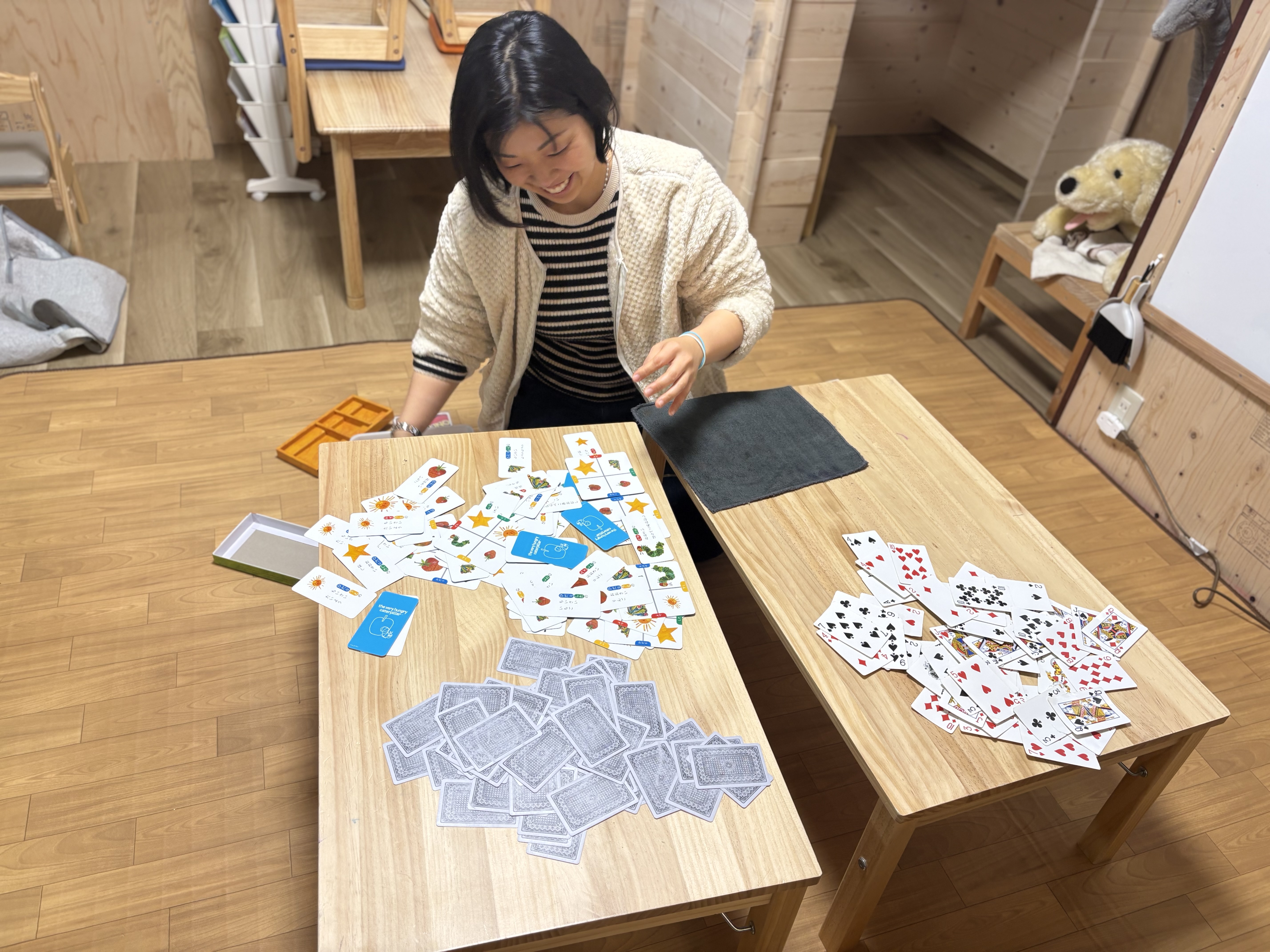 スタッフのキョンキョンはトランプやカルタなど、一枚一枚服作業を笑顔で楽しむ。