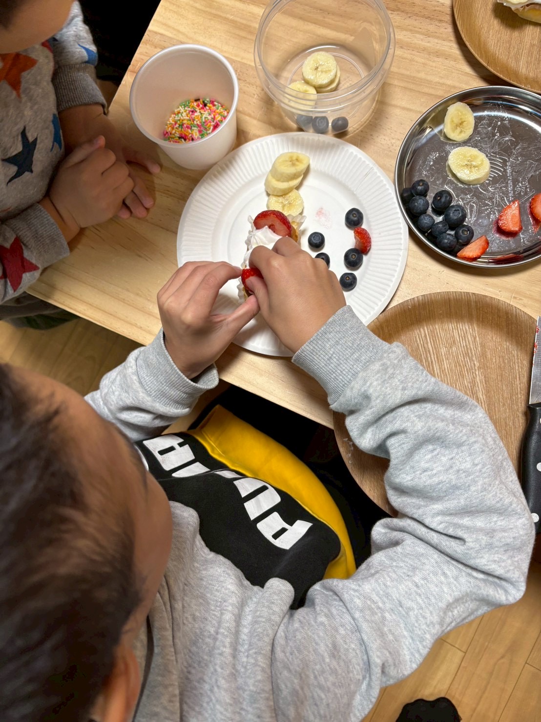 ケーキ早く食べたいよ。言いながら、たっぷりのクリームとイチゴを乗せる様子。