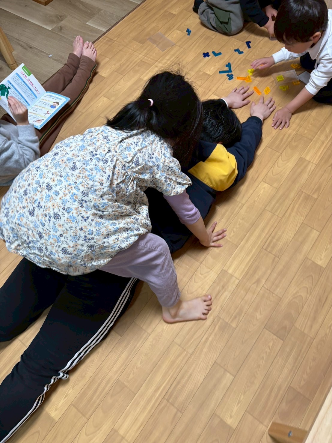 「せーのっ！」の掛け声で、複数人でスタッフの腕や足を引っ張る協力プレーの瞬間。