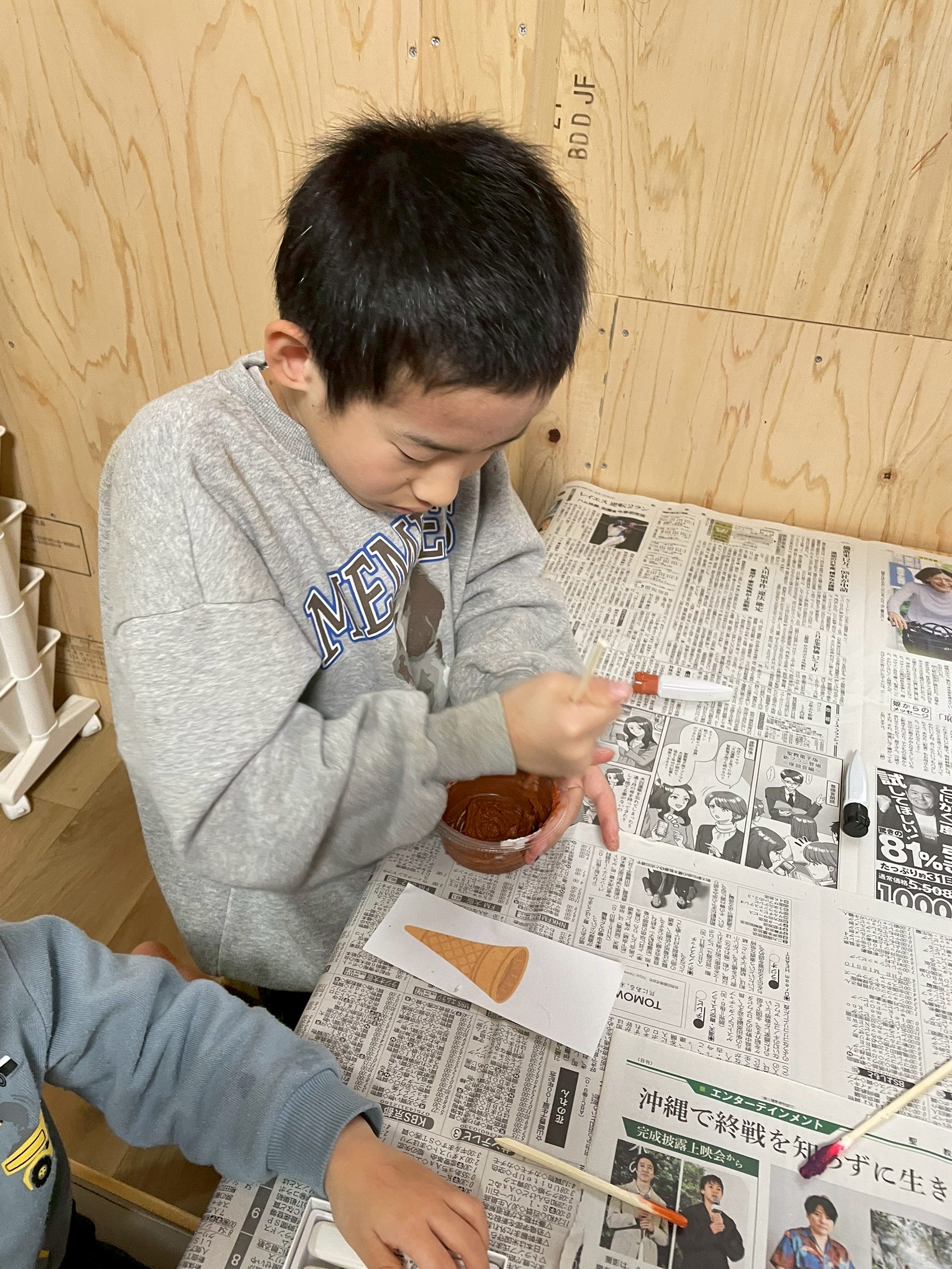 ボンドに好きな色の絵の具を投入し、トロトロの感触を楽しみながら混ぜ合わせる手元。