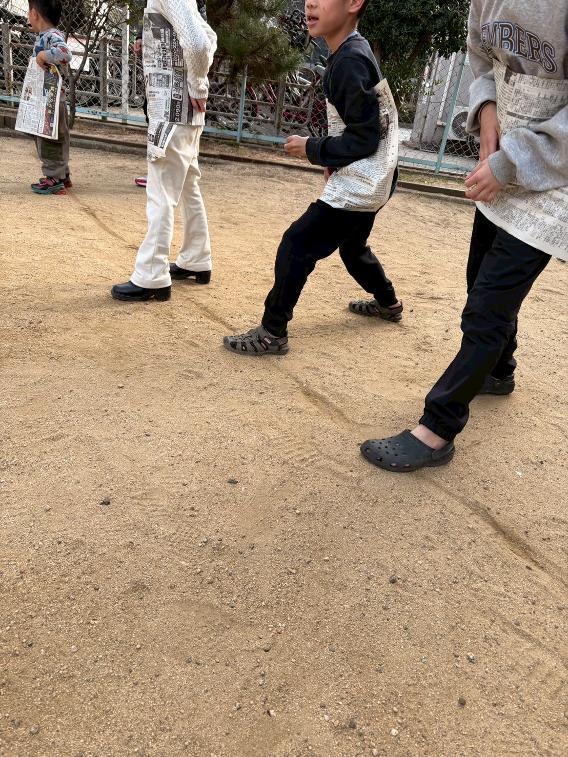 「修行、開始の合図！」
胸に新聞紙を当て、スタートラインで前を見つめる真剣な瞳。1枚の紙が、これから「ヒーローのマント」に変わる瞬間です。