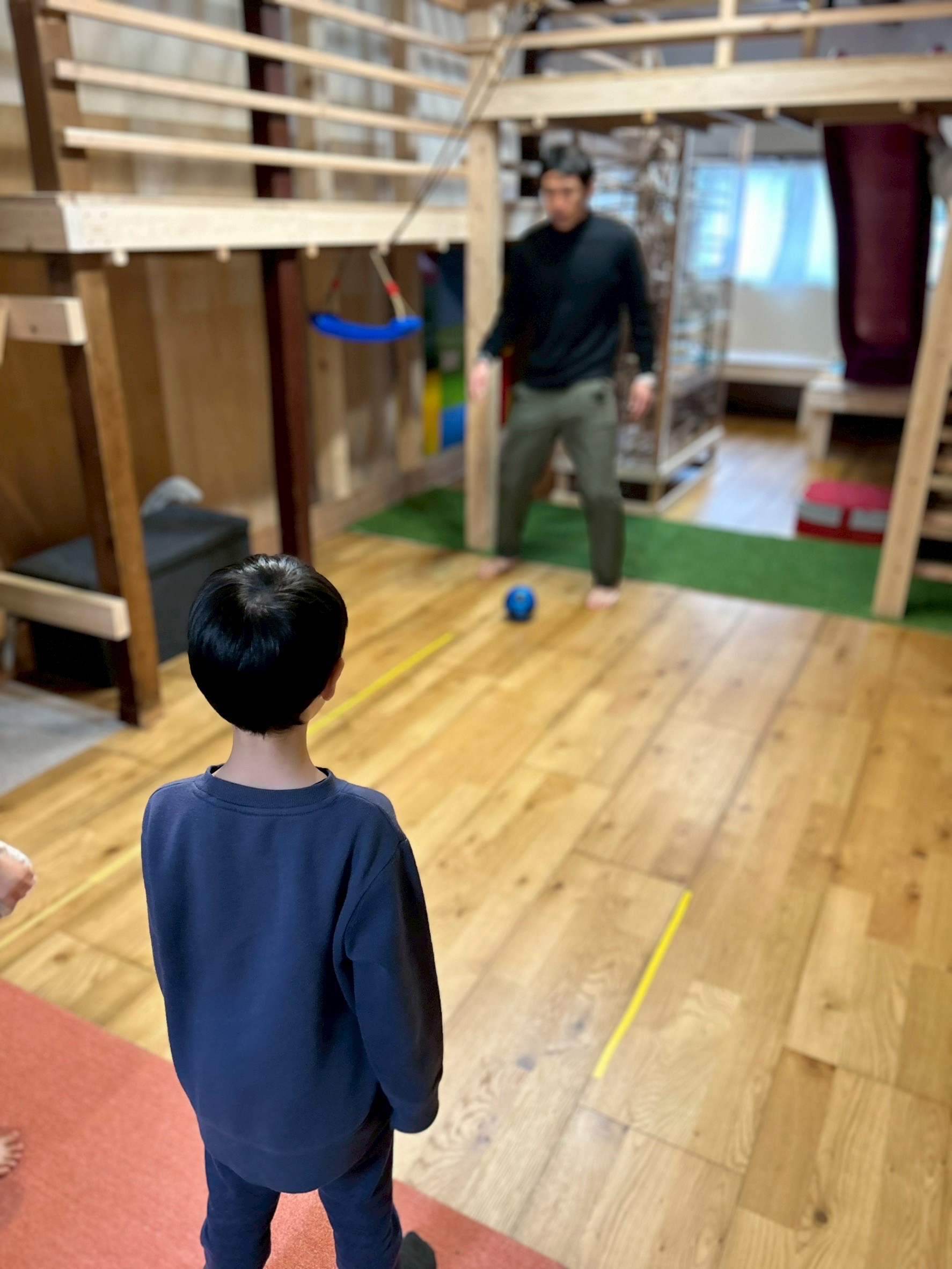 「光の連鎖を、ここから。」 こばやんさんと子どもたちがハイタッチをしたり、共に歩んでいる様子。一人ひとりの光が繋がり、ご家族や街全体を明るく照らしていく希望に満ちたラストショット。