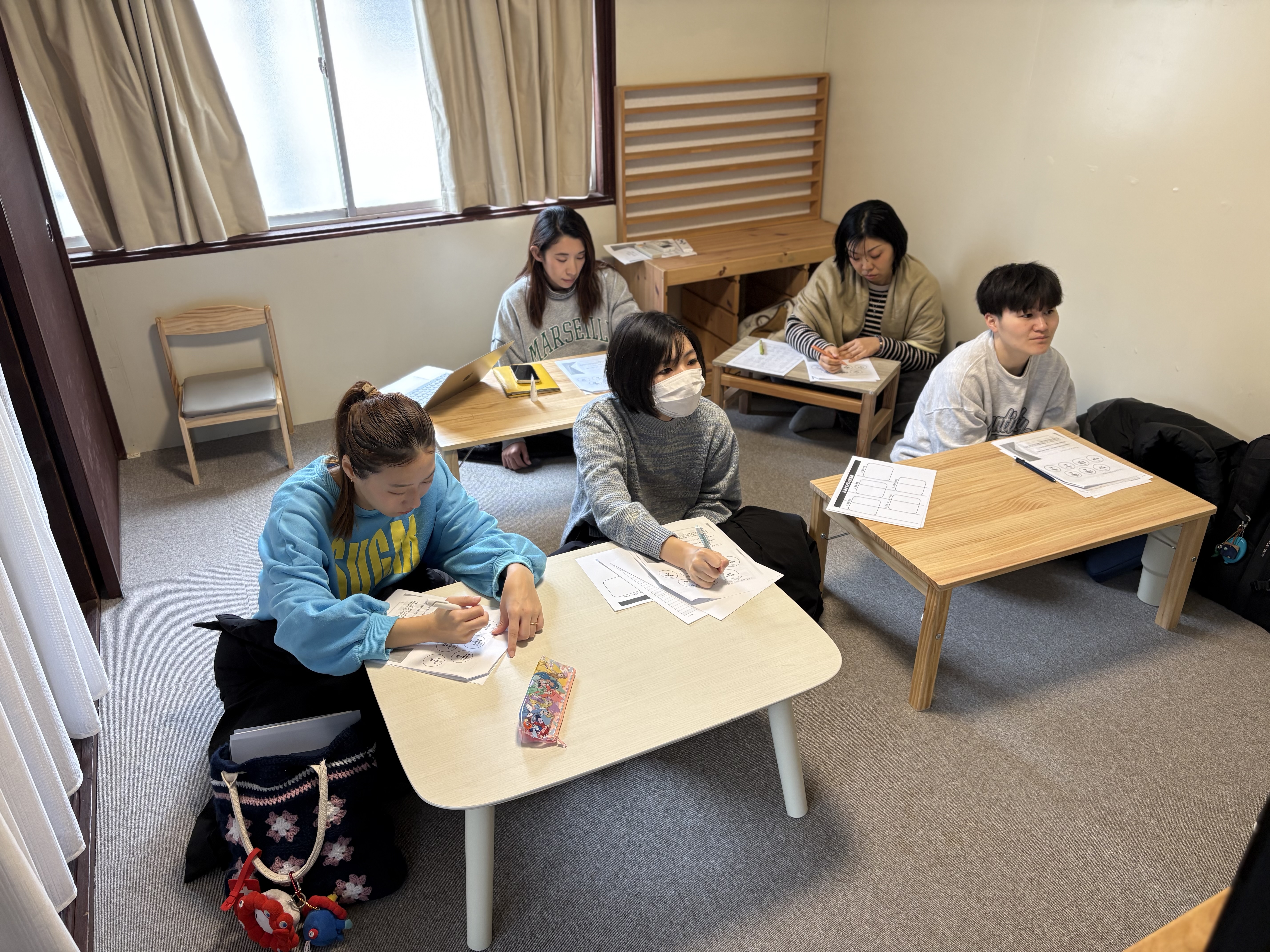 5領域を成長の地図に。」

スライドに映し出された5領域の図解と、それを指し示しながら具体的な支援を議論する様子。知識を「実践」へ変えるための、スタッフ同士の活発な意見交換。