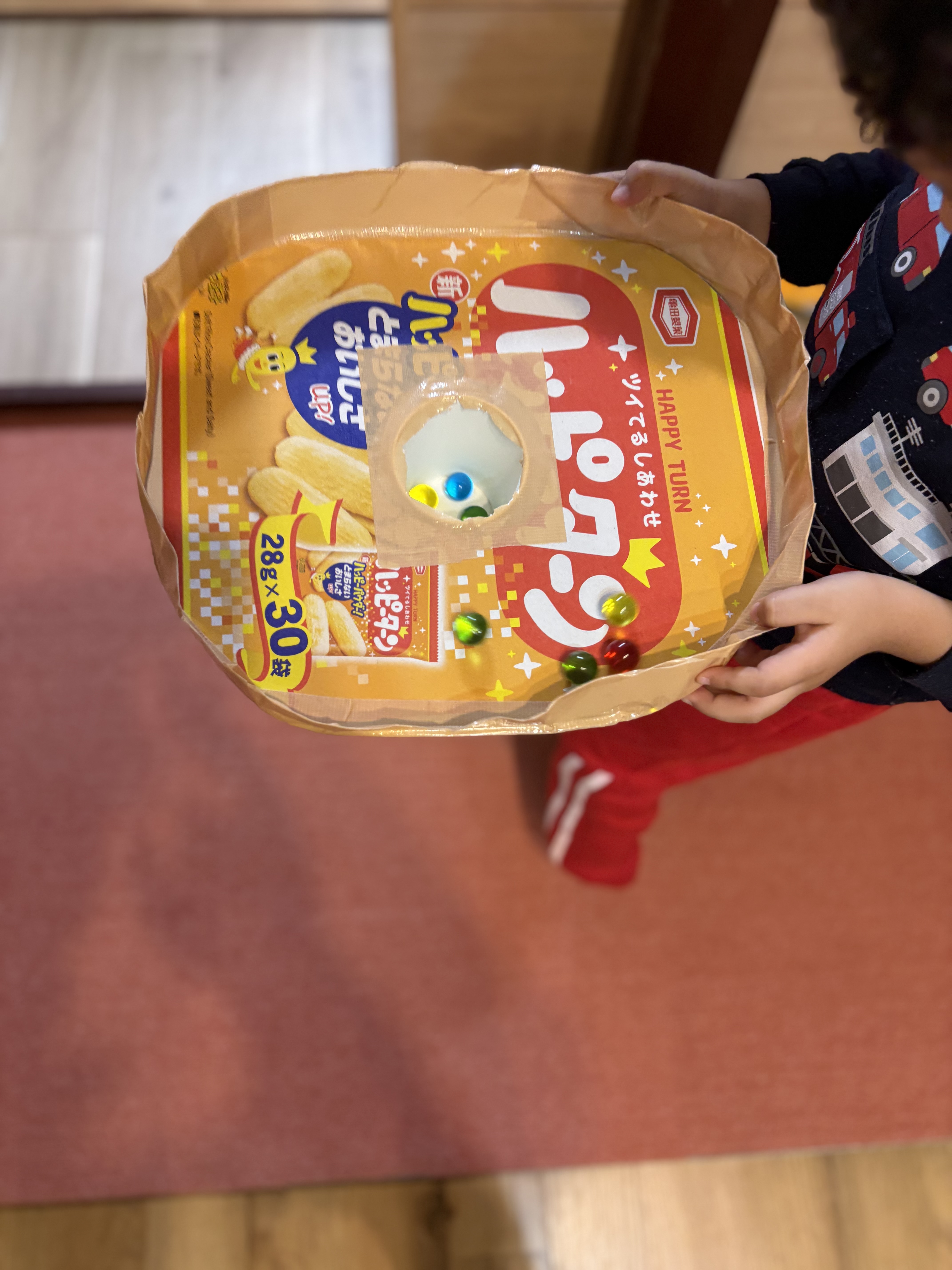 「スタッフの愛が詰まった自信作！」

段ボールと紙コップでできた温かみのある「ビー玉落としマシーン」の全体像。