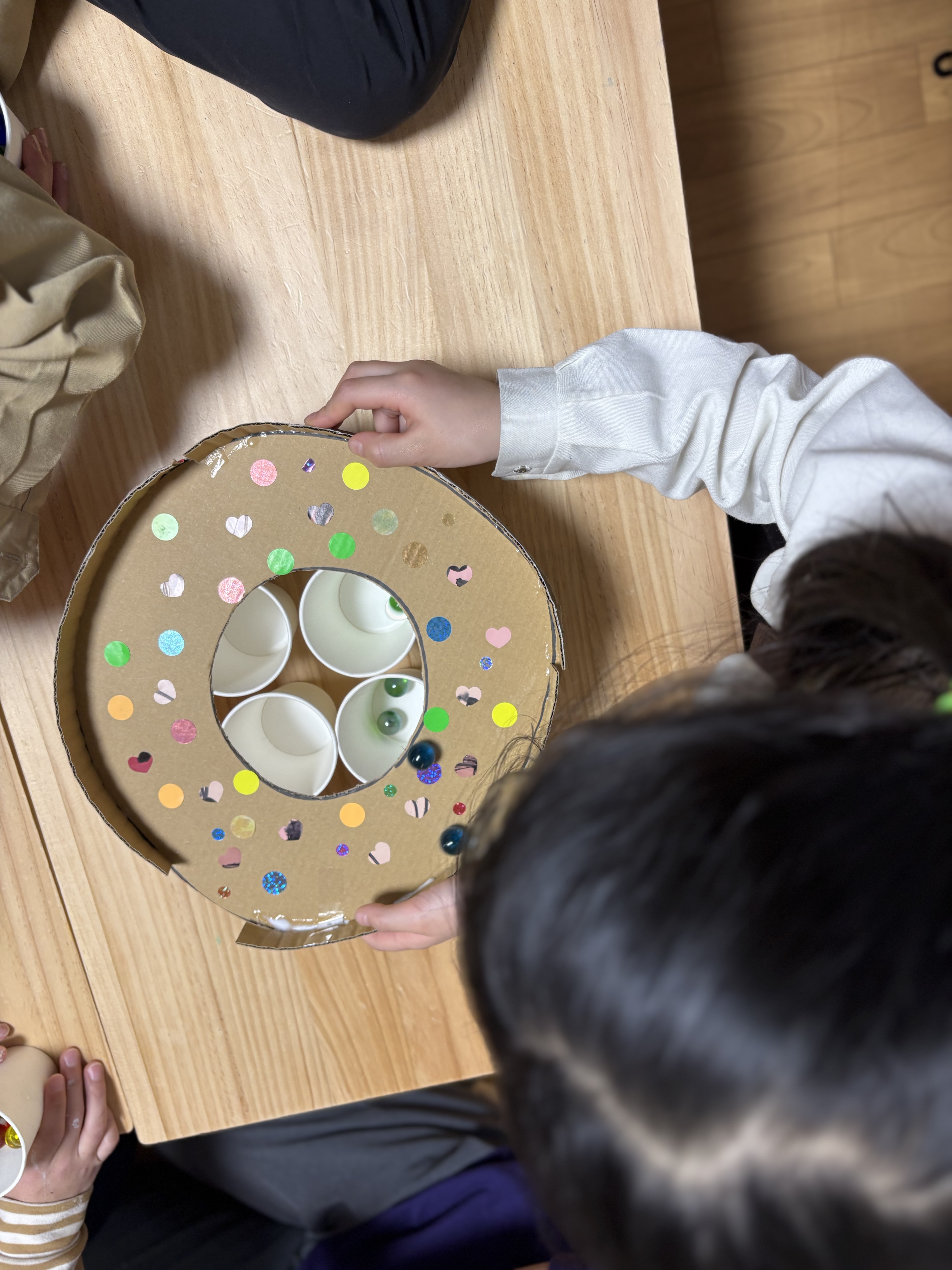 「おしい！あともうちょっと！」

ビー玉が穴から逸れた瞬間、自分のことのように悔しがり、励ます仲間の温かい姿。