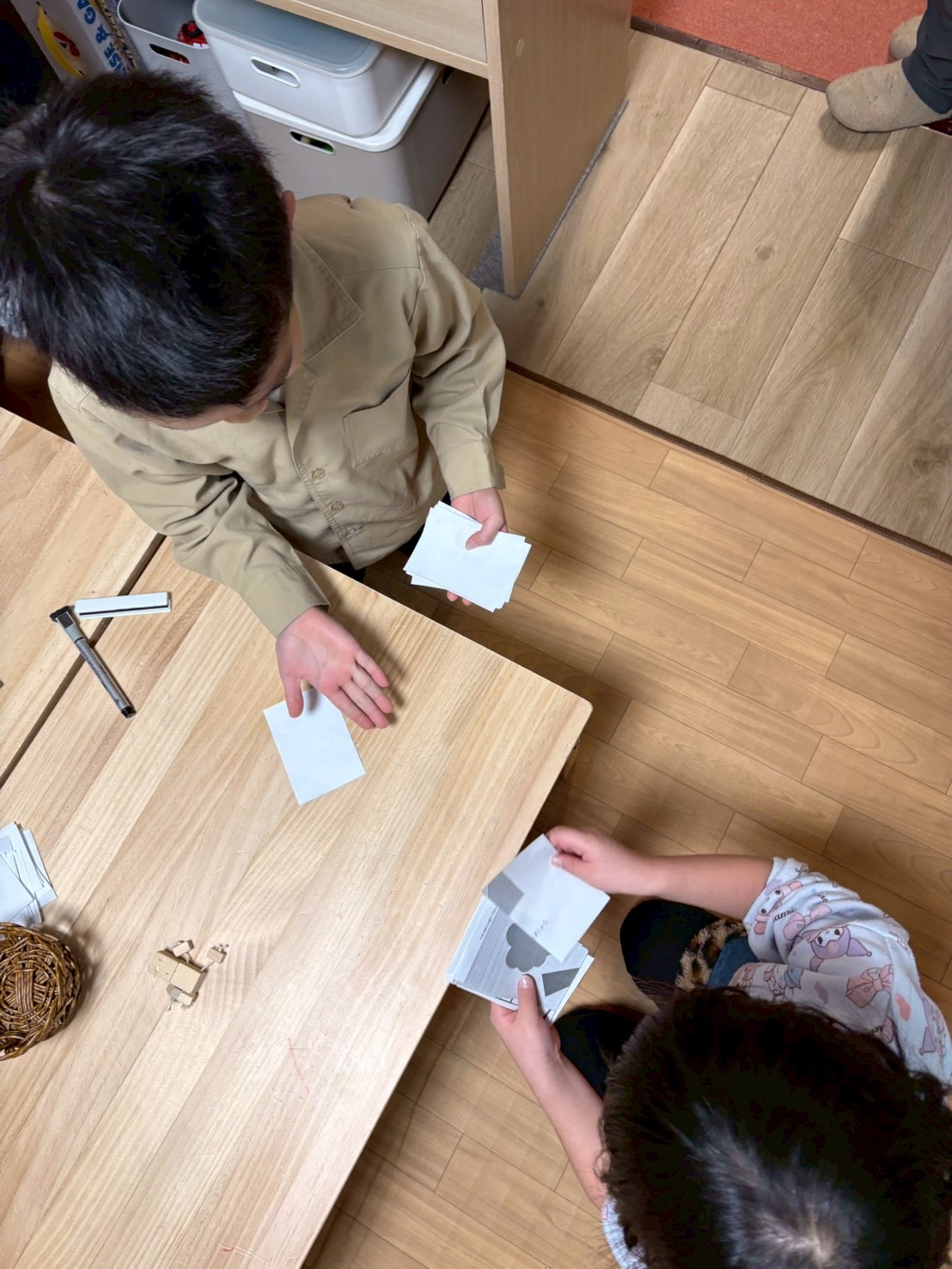 「バトルの前の、大切な儀式。」

お互いに持ち札をテーブルに広げ、「何枚でやる？」と顔を見合わせる緊張感のあるスタートシーン。