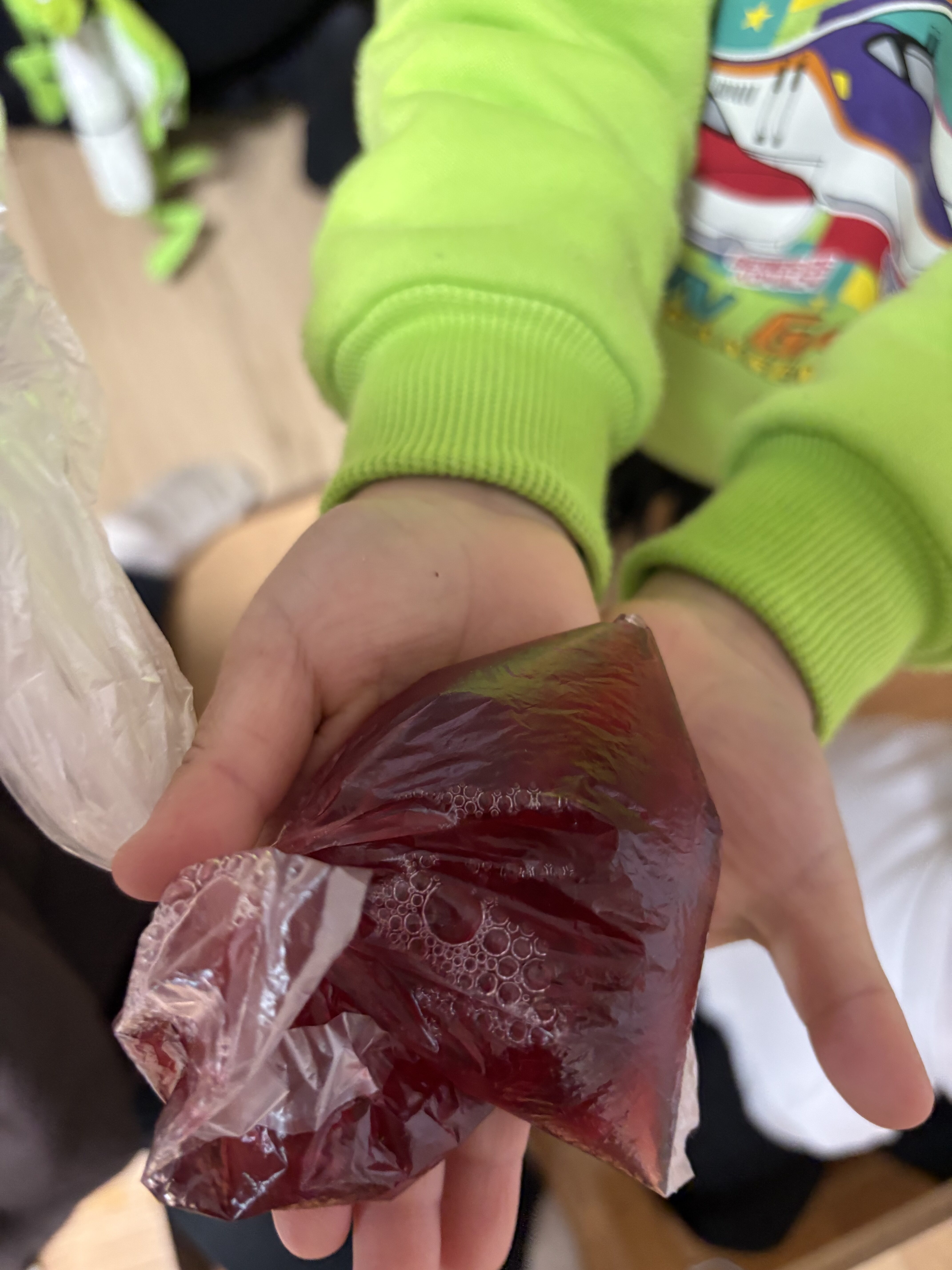 みてみて!!僕のはブドウジュースだよと、袋にこぼさずに入れたよと自信を持つ男の子。