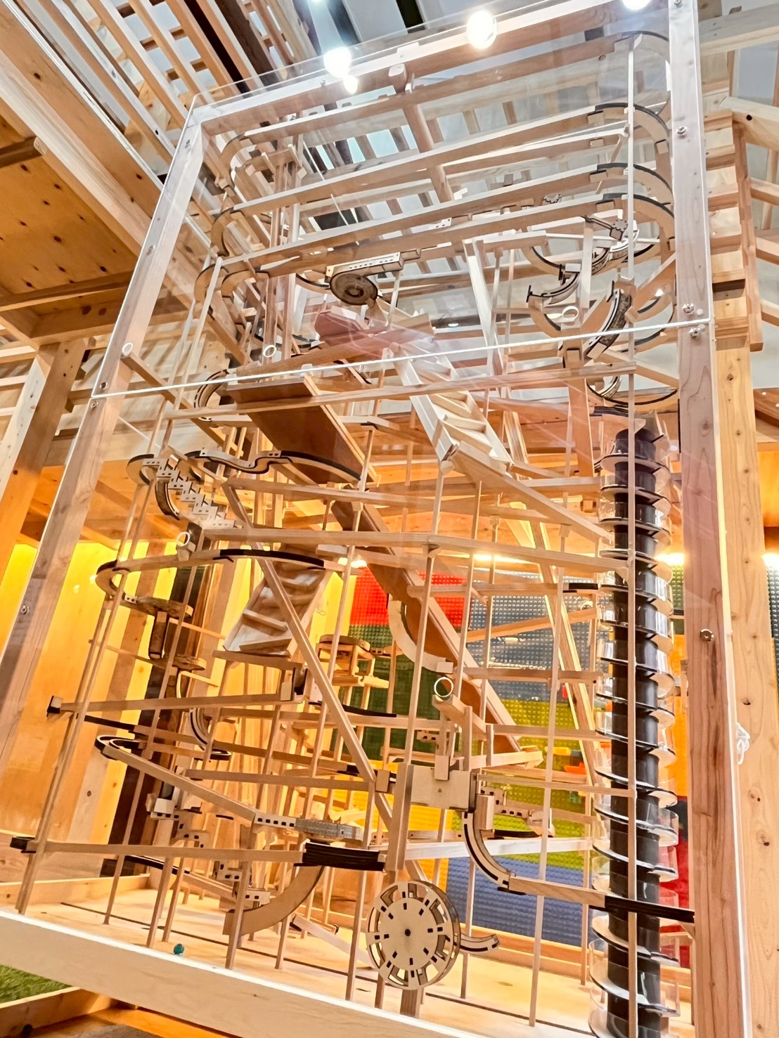 「五感で味わう、木のシンボル。」
高さ2m超の巨大マーブルランの全体像と、その大きさに圧倒されつつも、ワクワクが止まらないお子様の対比ショット。広がる木の香りまで伝わるような、開放感のある1枚。