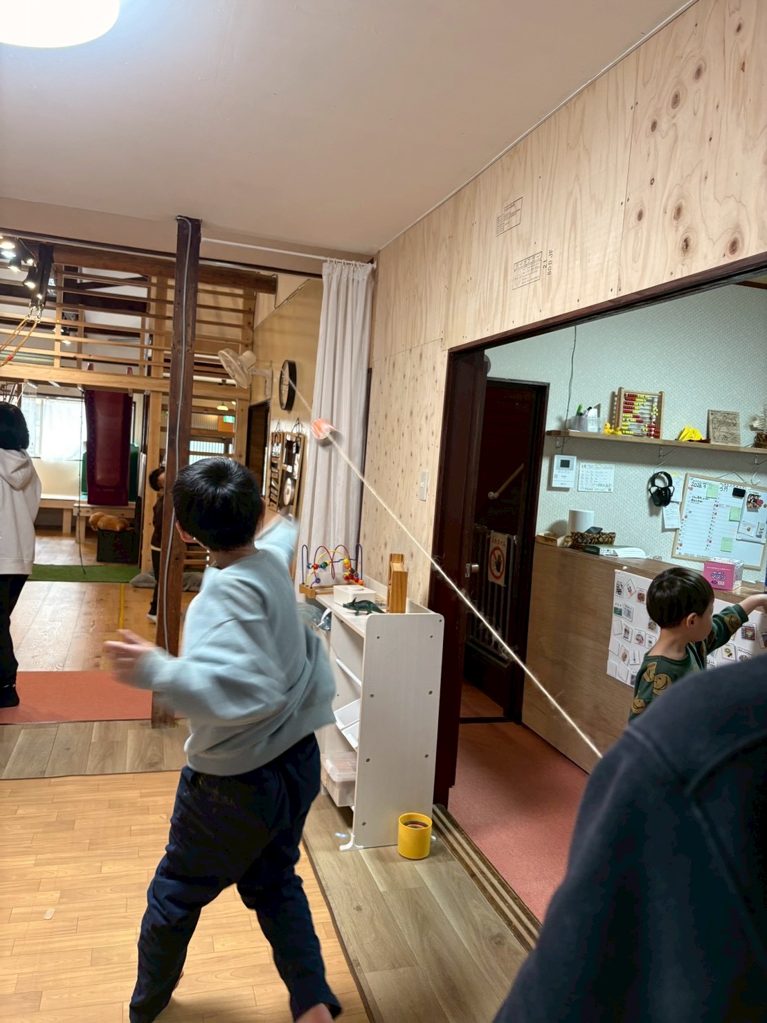 「届け、2階のゴールへ！」

見上げる子どもたちの後ろ姿。自分たちの放った箱が2階の高さまで到達するのを、首を長くして追いかける「追視」のトレーニング。