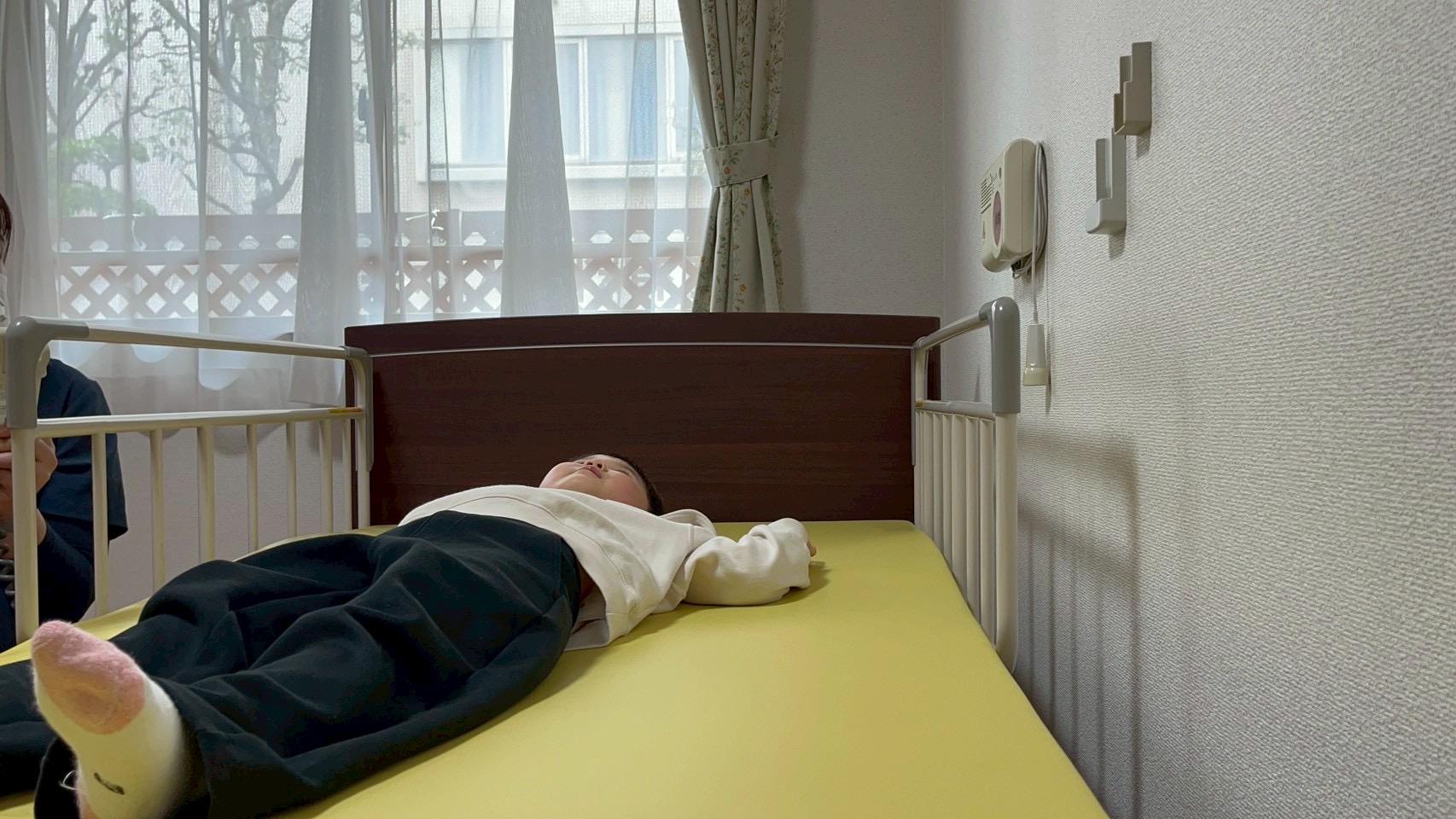 「ベッドが動く!不思議な視界。」
ボタン操作でゆっくり起き上がるベッドに、驚きと感心の表情を浮かべるお子様。介護技術への敬意が育つ1枚。