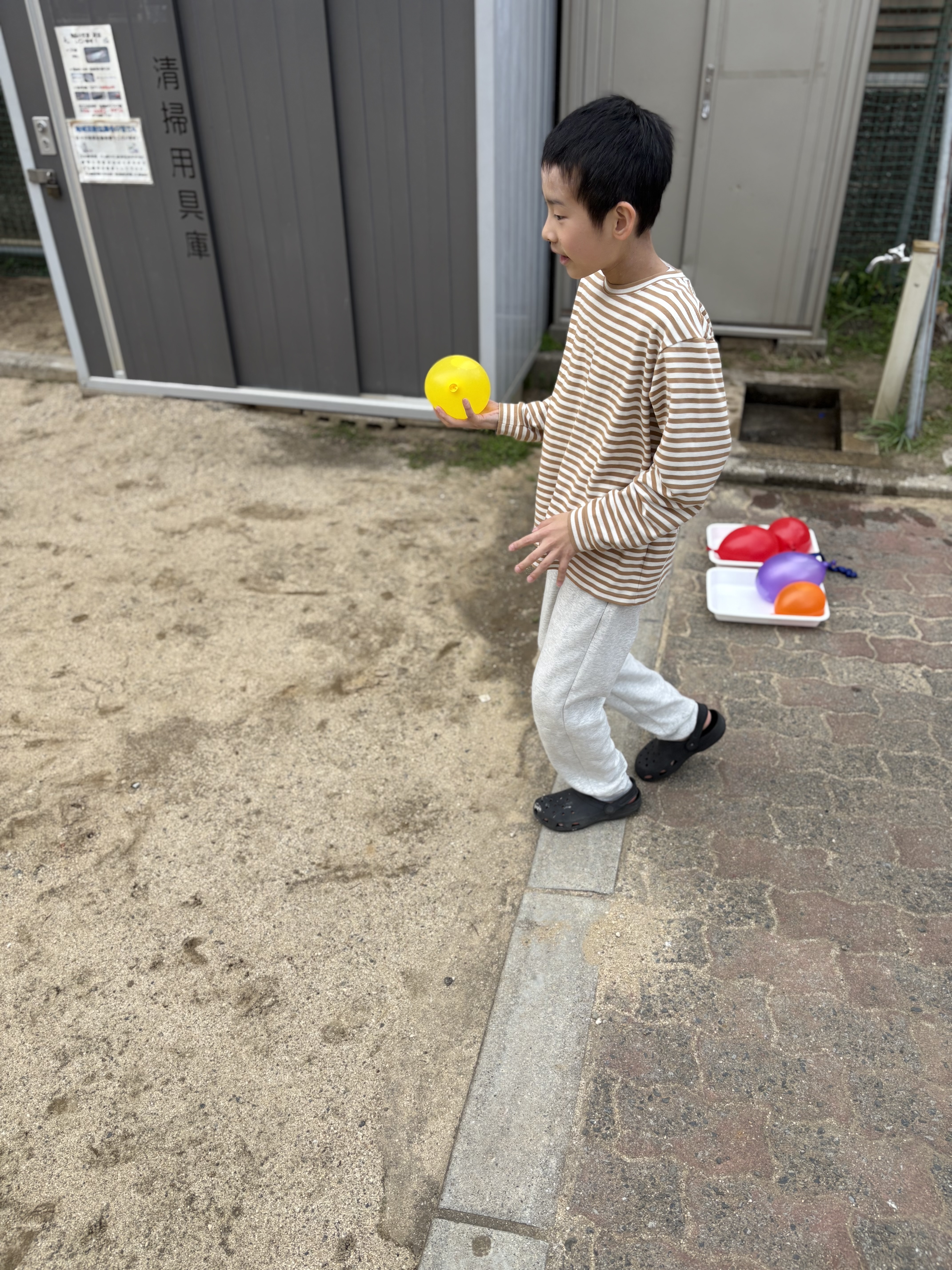 水風船、テイクオフ！」

太陽の光を反射してキラキラ光る水風船を、お庭で地面に投げる直前の躍動感あるショット。