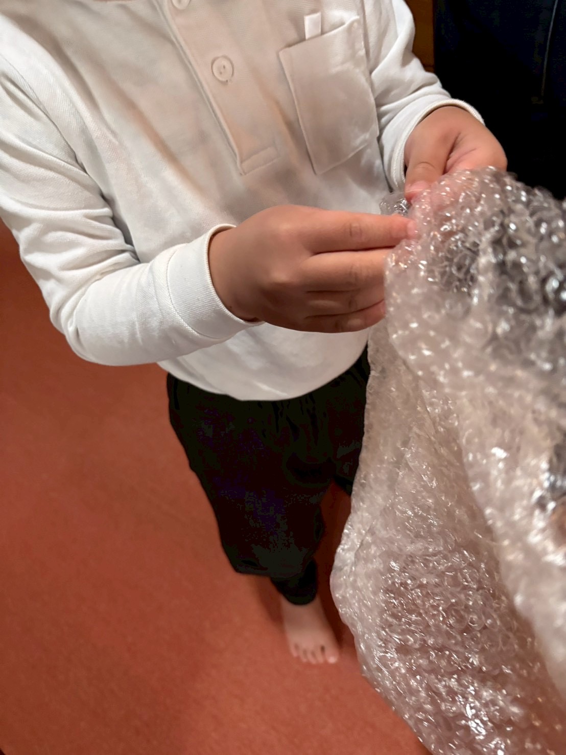 「一粒への情熱、ロックオン。」

指先でプチプチを一粒つまみ、全神経を集中させて潰そうとするお子様の横顔。指先の筋力を育む「本気の微細運動」。