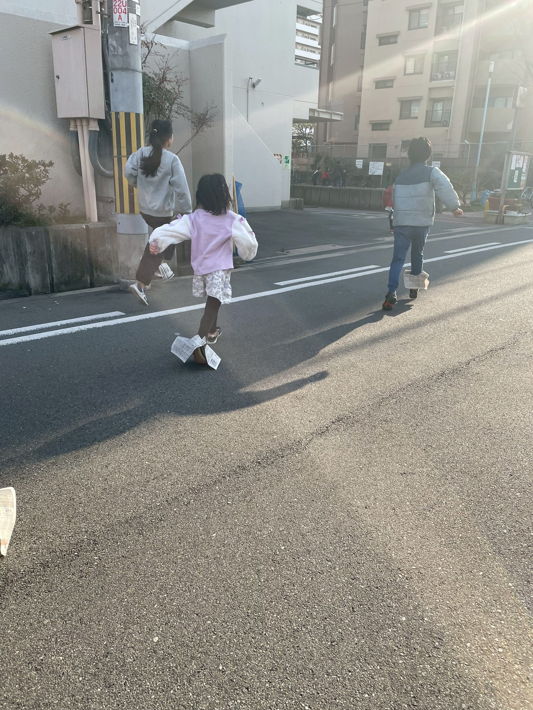 「スタート直前の、嵐の前。」

片足に新聞紙を履いた子どもたちが円になり、今か今かと合図を待つ、静かな緊張感。