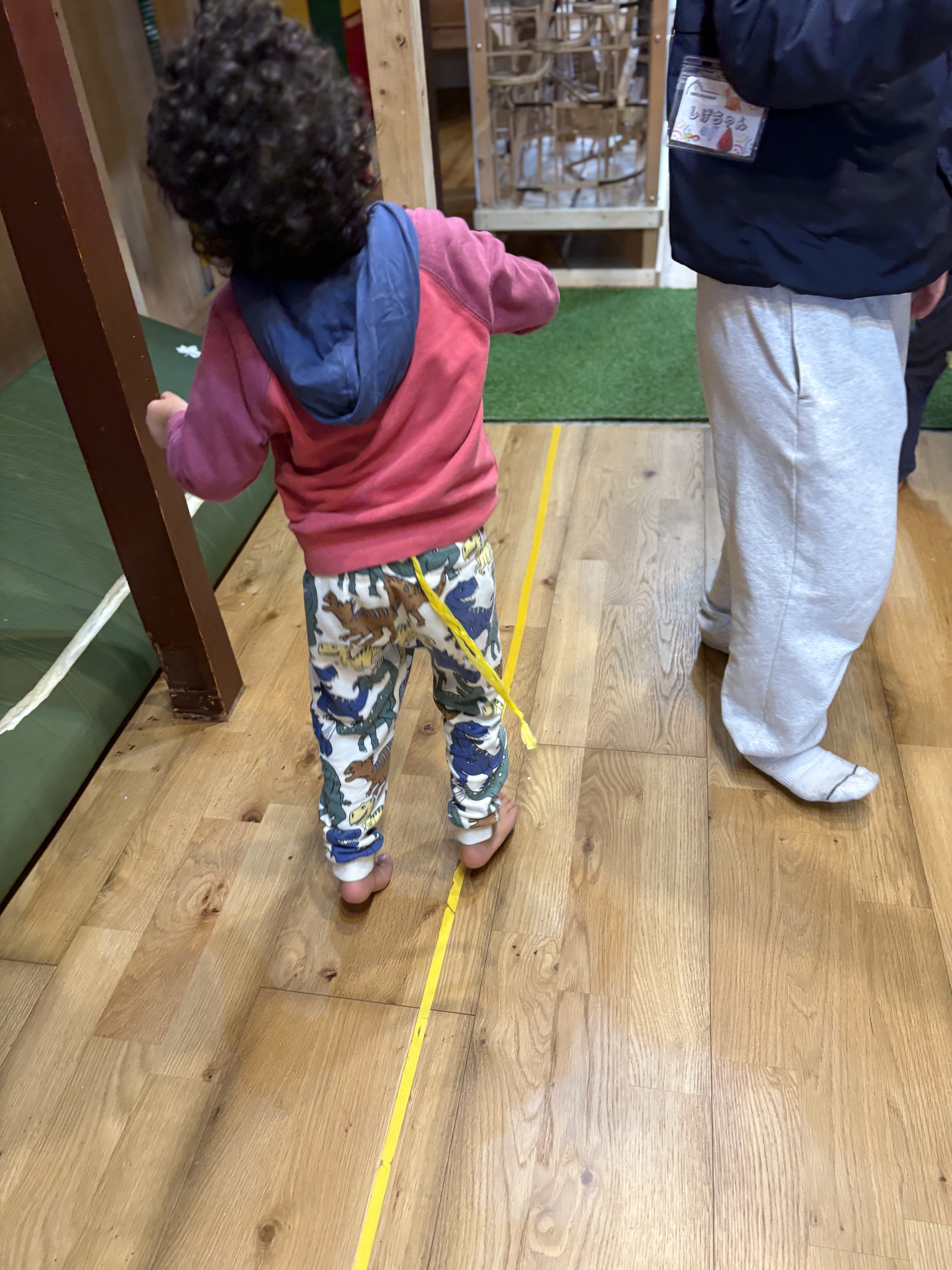 「フィールドを読み解く、真剣な眼差し。」
木工遊具を見上げ、「どこに隠れようか?」「どこから攻めようか?」と戦略を練る、スナイパーのような鋭い瞳。