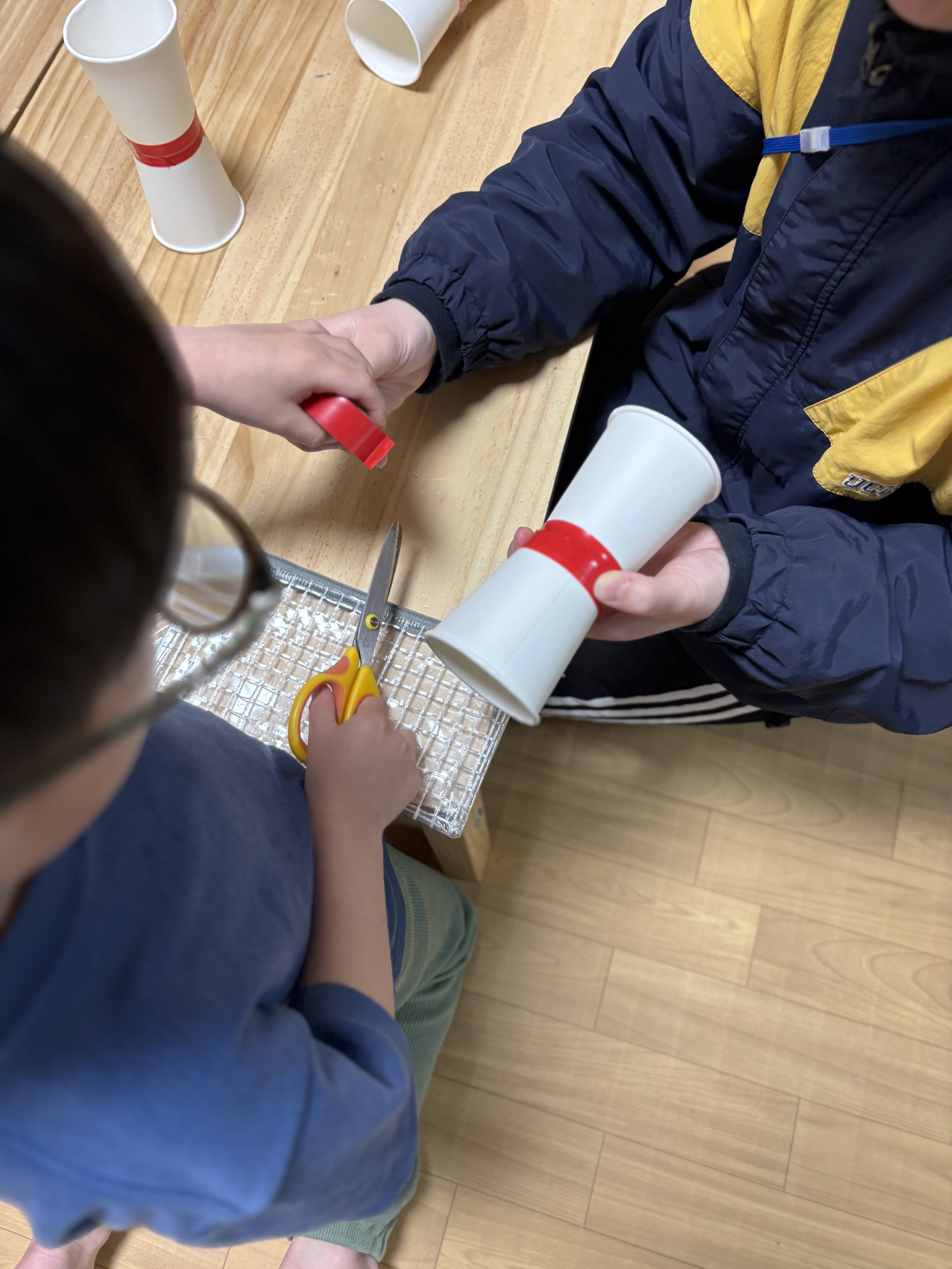 スタッフにお手伝いしてもらいな柄も、自分の飛行機を作る男の子。