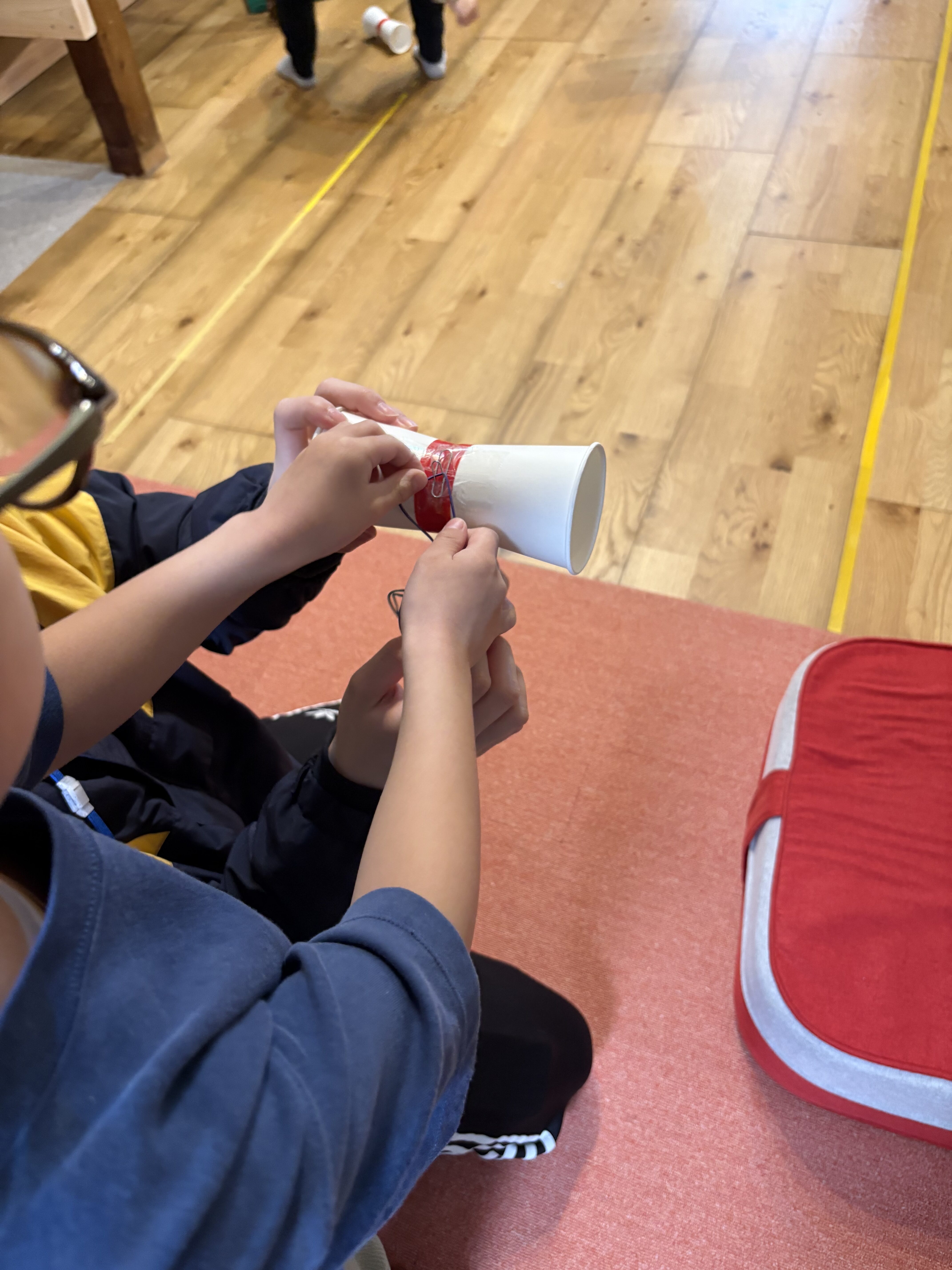 「輪ゴムを引っ掛ける、繊細なフック。」
完成したエンジンのゴムを、飛ばすための指(または専用のフック)に引っ掛ける、力加減と空間認知の交差。