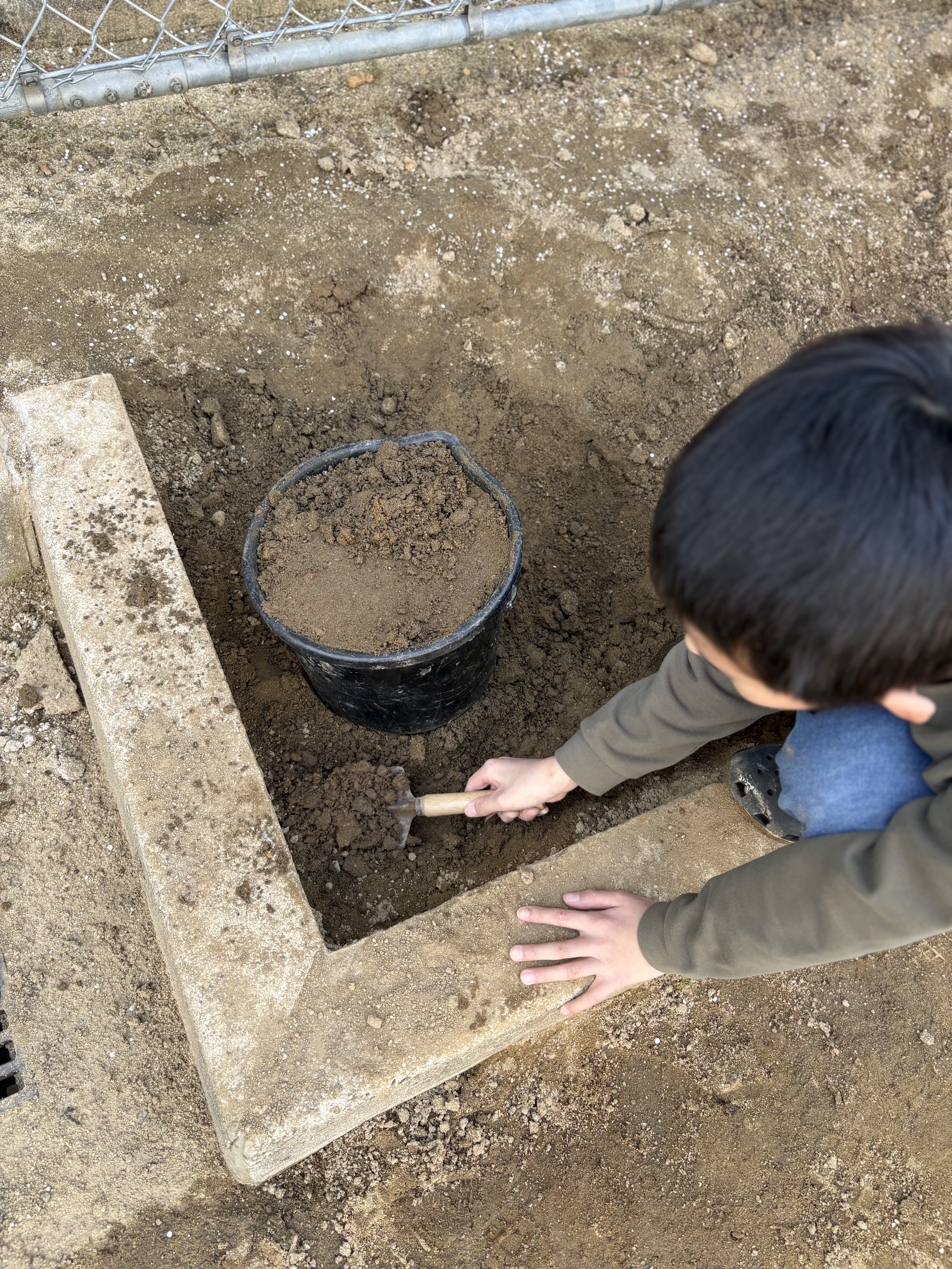 水浸しになったグランウドに土を足して整備するために準備している様子。