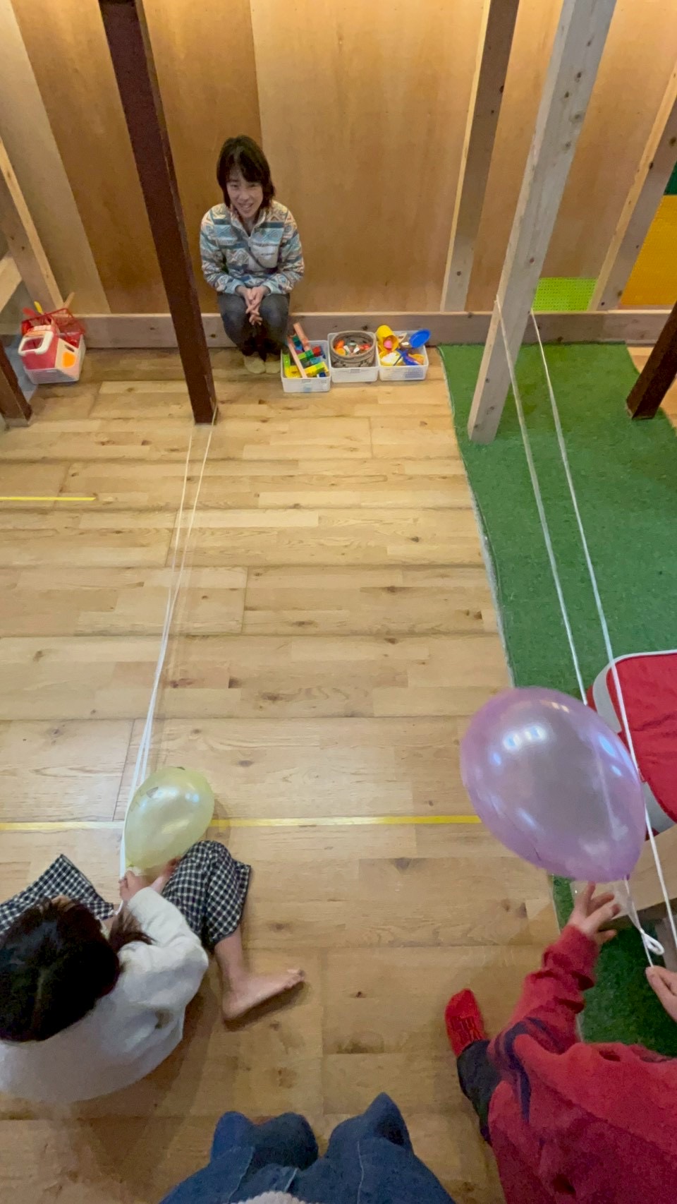 「空中に浮かぶ、好奇心のターゲット。」
天井近くに浮かぶ風船と、そこから伸びる紐を見上げる、期待に満ちたキラキラした瞳。