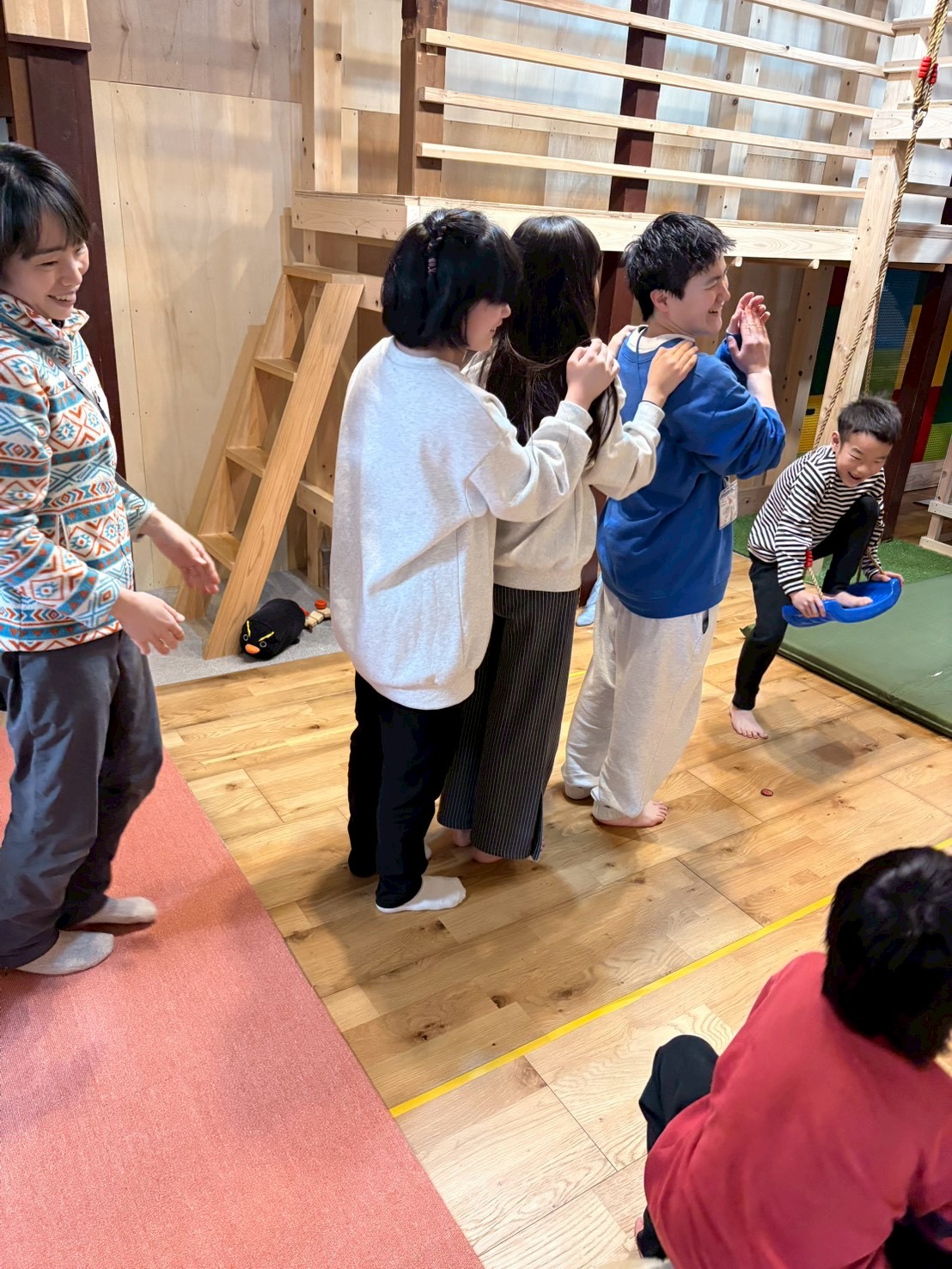 「一列の絆、準備はいいかい?」
子どもたちがスタッフの合図を待ち、背筋を伸ばして一列に並ぶ、期待感に満ちたバックショット。