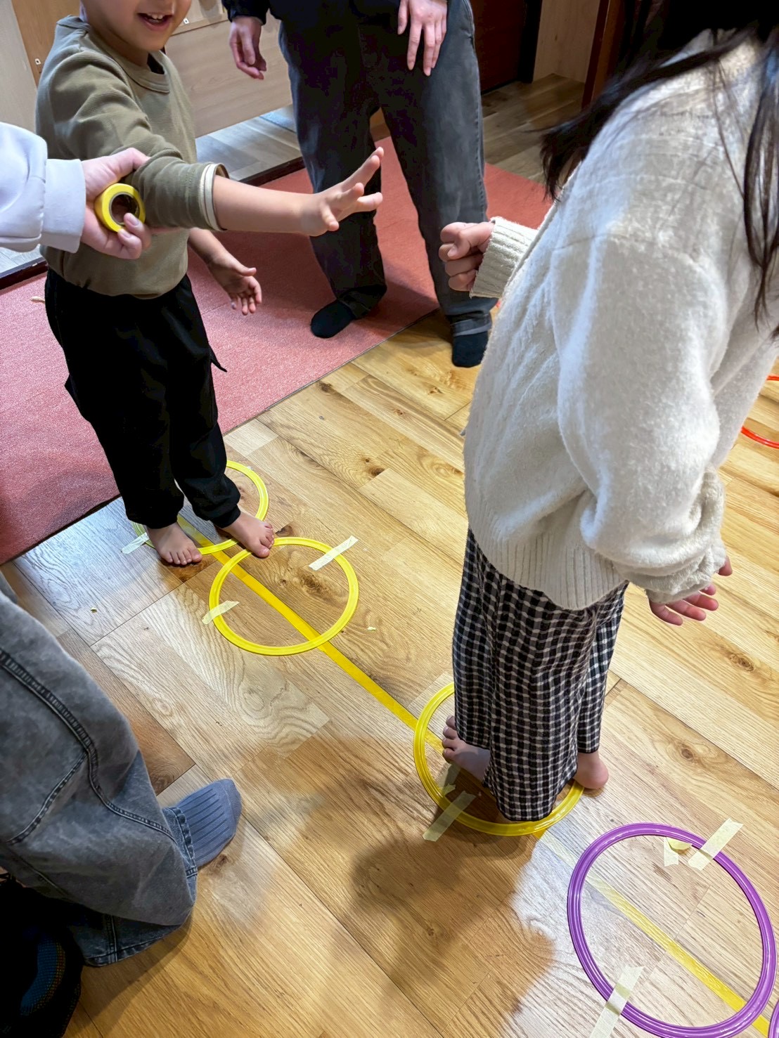 「全力疾走!バトン(フープ)を繋げ。」
フープを手に、次の仲間へとバトンを渡すために一生懸命走る、躍動感あふれるスポーツの1コマ。