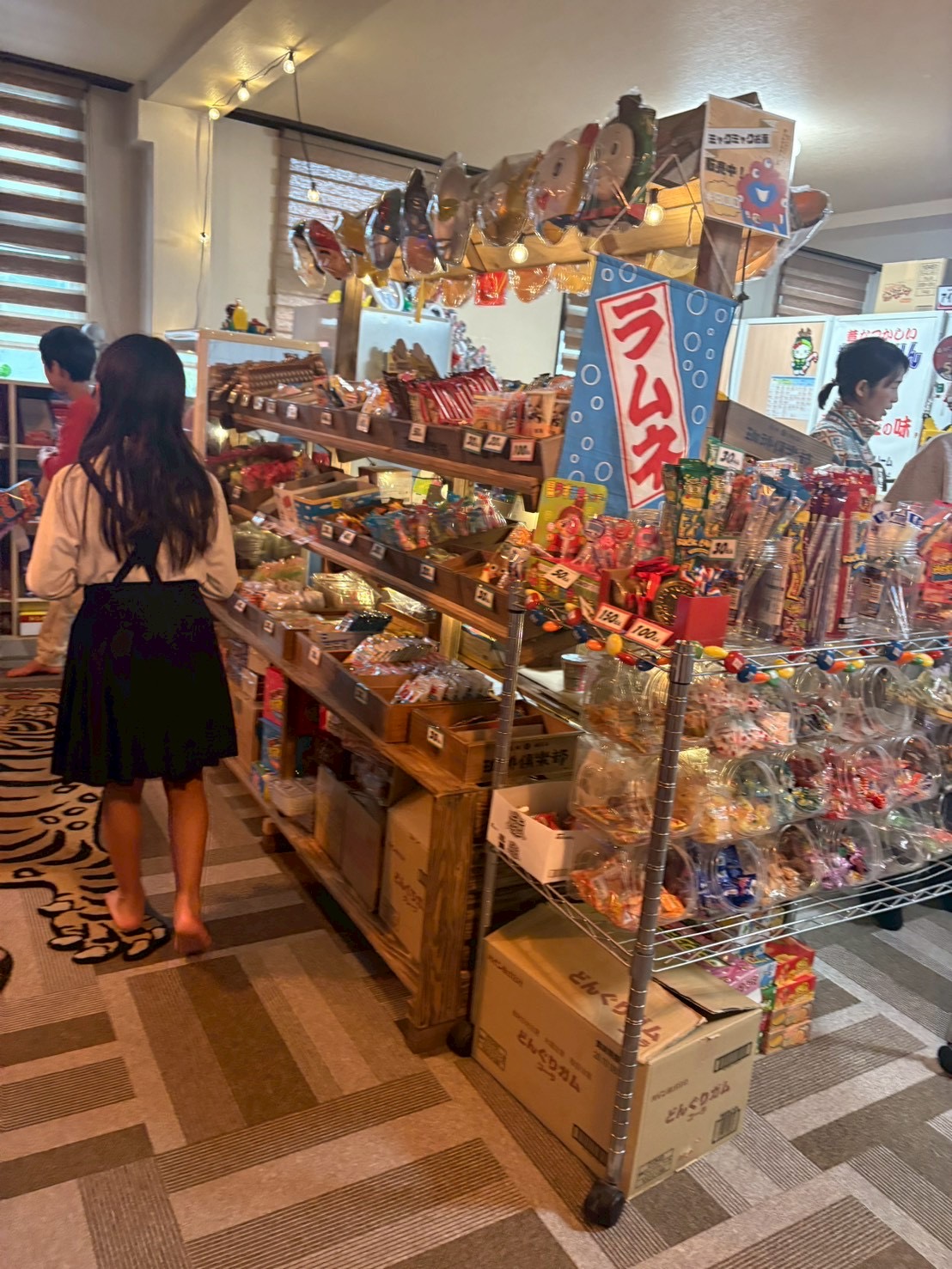 「棚いっぱいの、迷宮。」

ずらりと並ぶおやつを前に、圧倒されて立ち尽くす（でも目はキラキラな）後ろ姿。