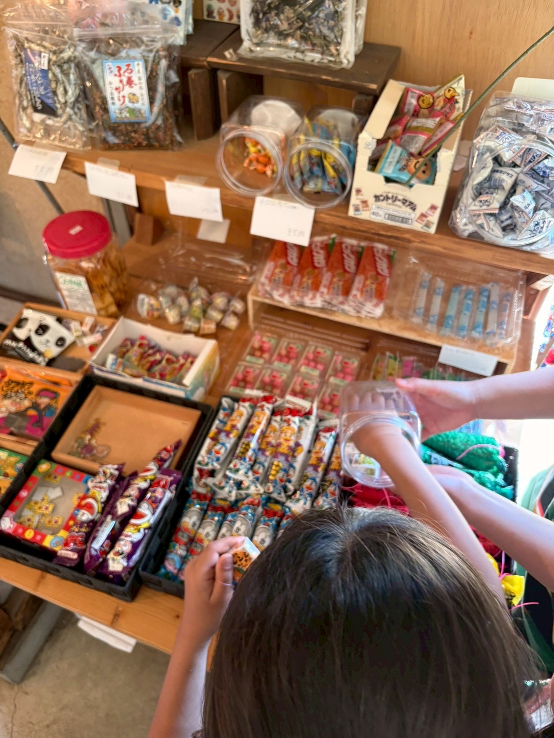 「自分の手で、手渡すドキドキ。」

お金を店長さんに渡し、おやつを受け取る。社会の仕組みを肌で感じる、小さな緊張の瞬間。