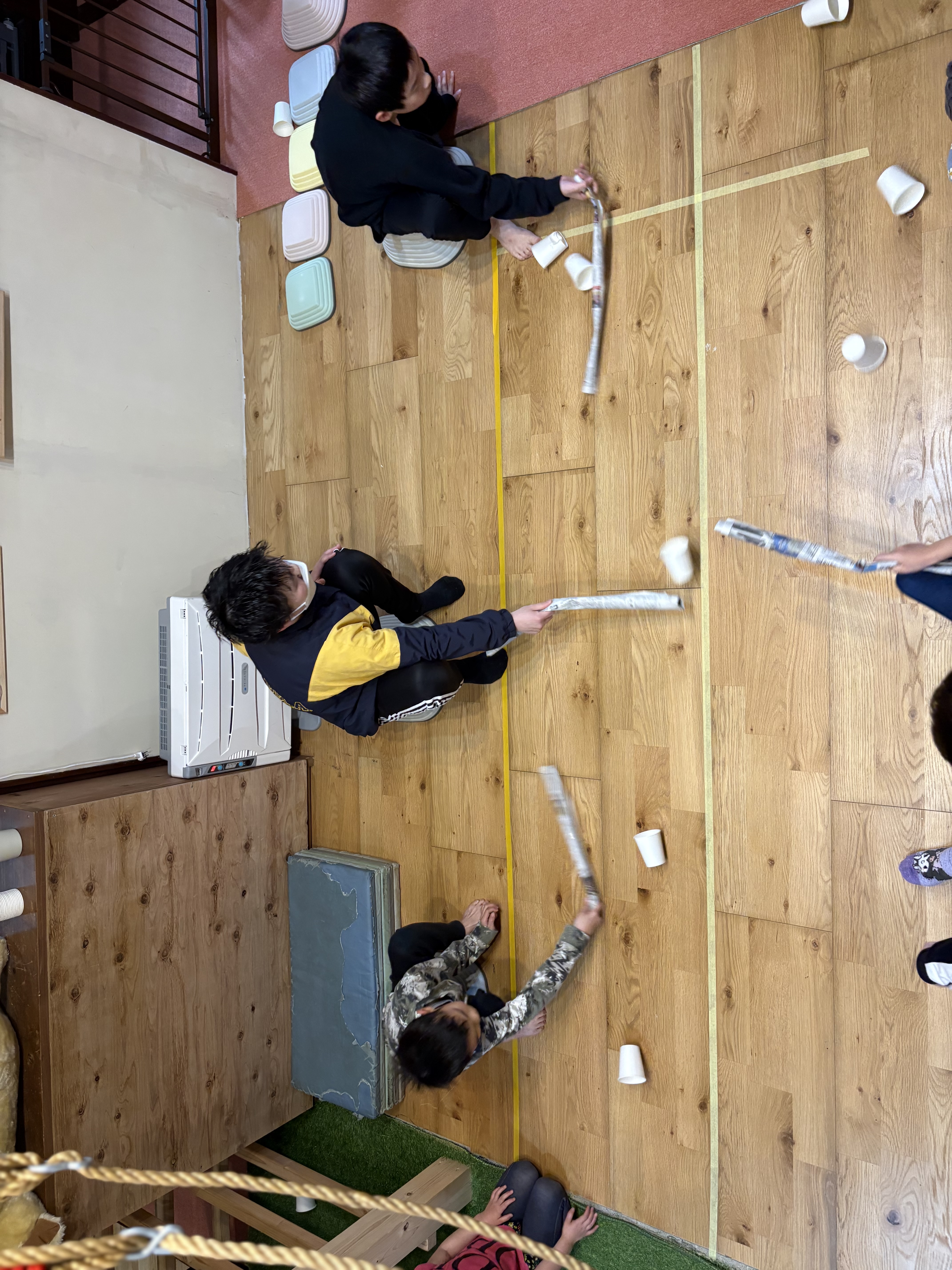 「カラカラと舞う、白いコップ。」

棒の先端がコップを捉え、相手陣地へ滑っていく動的な瞬間。ピントの合ったコップとボケた背景の対比。