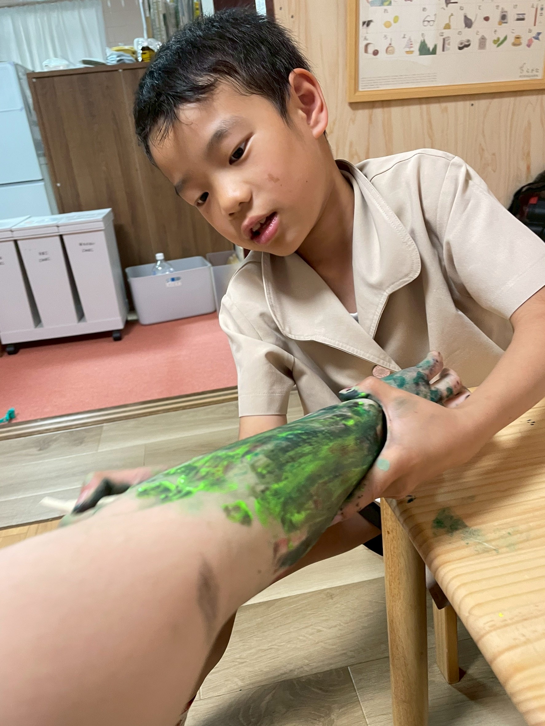 「肌に触れる筆の、くすぐったい感覚。」

腕に絵の具を塗られ、しげちゃんが思わず身悶えする「触覚」のコミュニケーション。