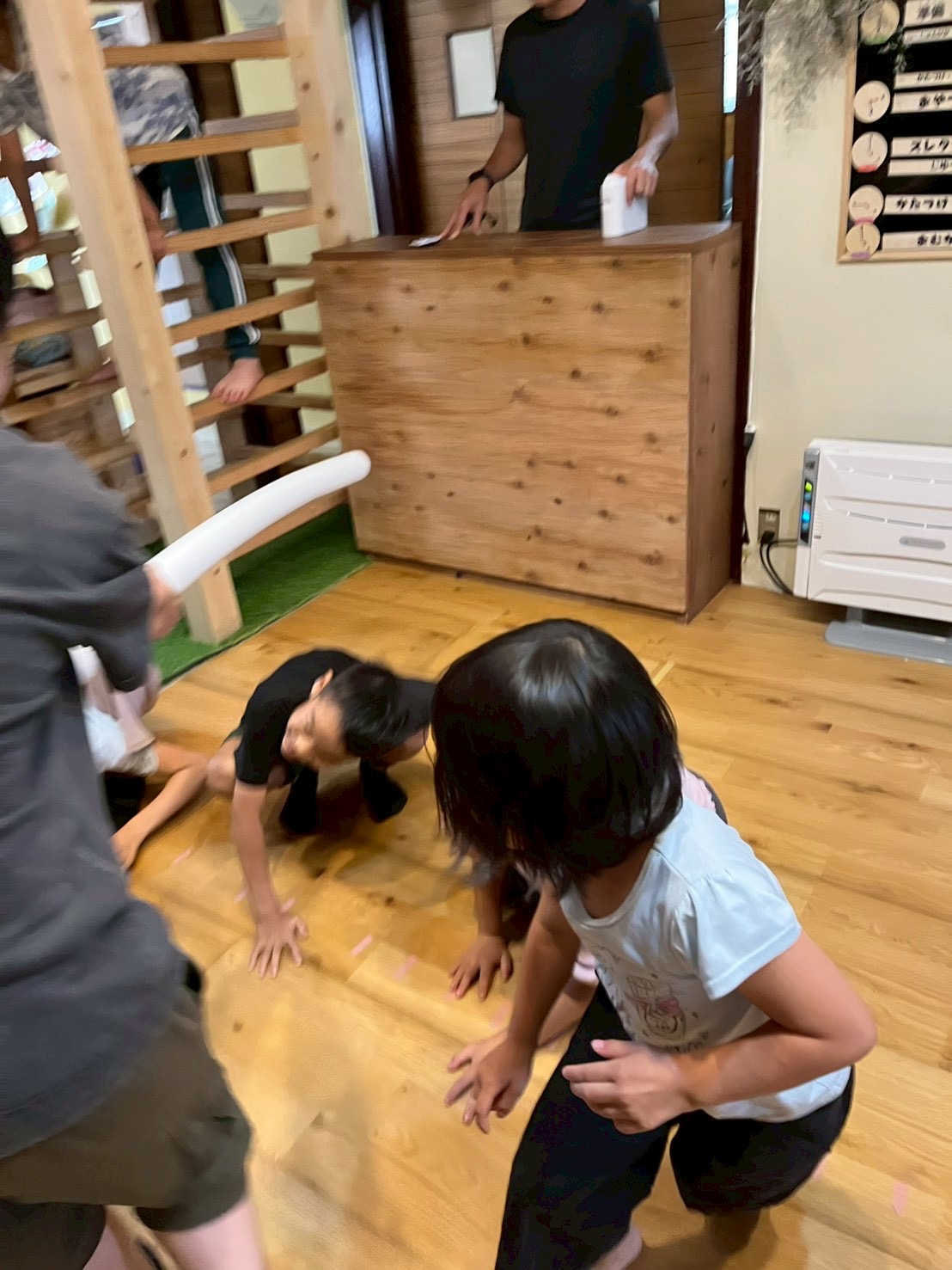 「頭上を通過！どすん！と全員スクワット。」

高い棒をよけるため、列の先頭から後ろまでみんなが一斉にサッと腰を落として姿勢を低くする、息の合ったシンクロカット。