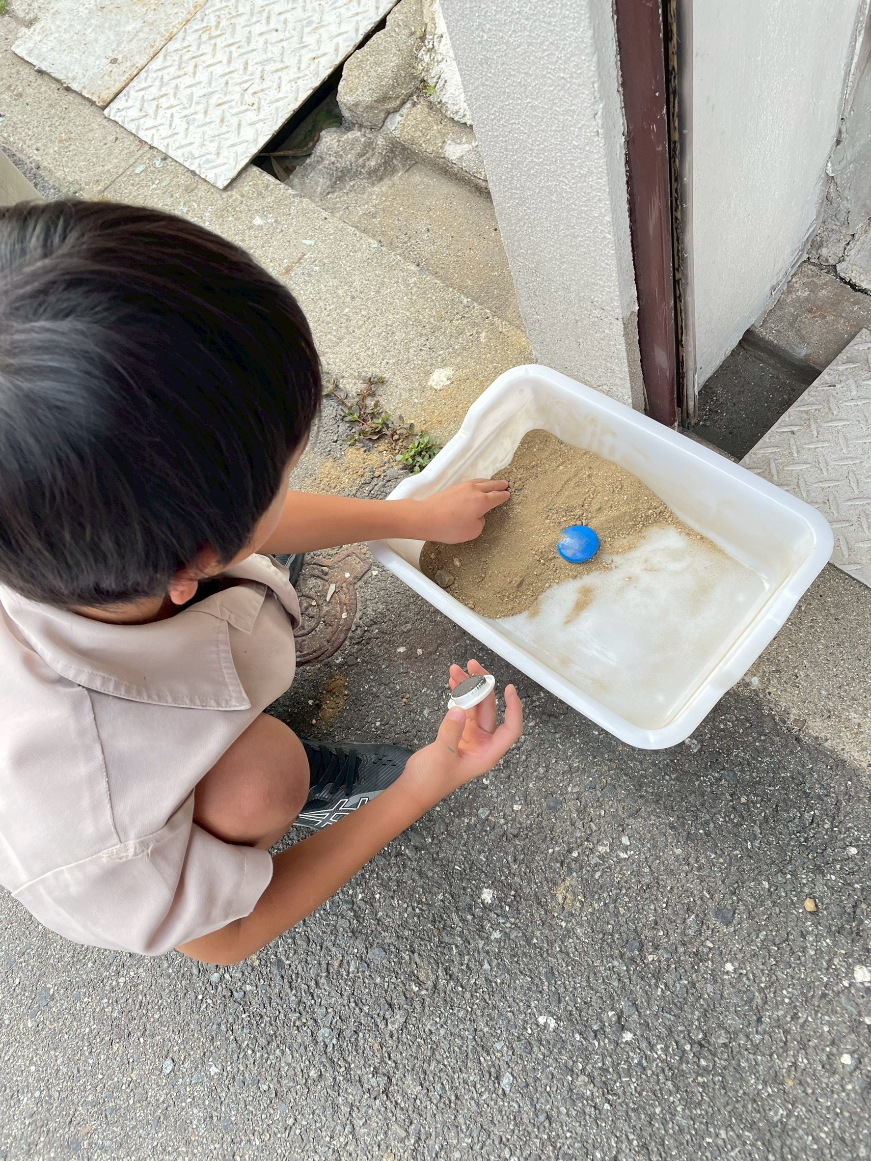 「なんかペタペタする!手のひらで感じる見えない力。」
砂鉄が磁石に引き寄せられるググッとした手応え(固有覚)を感じて、「おっ?」と驚いた表情を見せる子どもの横顔。