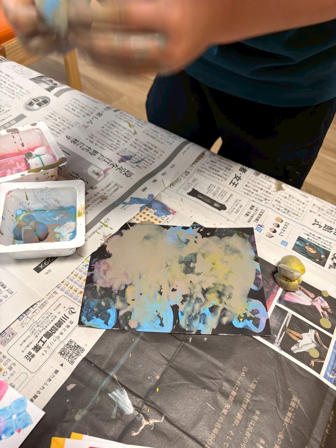 「狙いを定めて……力加減をコントロール！」

画用紙に向かって、狙った場所にめがけてスタンプを優しく「ポン！」と押し付ける瞬間のカット。目と手の協調運動や、弾力を確かめる真剣な職人のような眼差しが光ります。