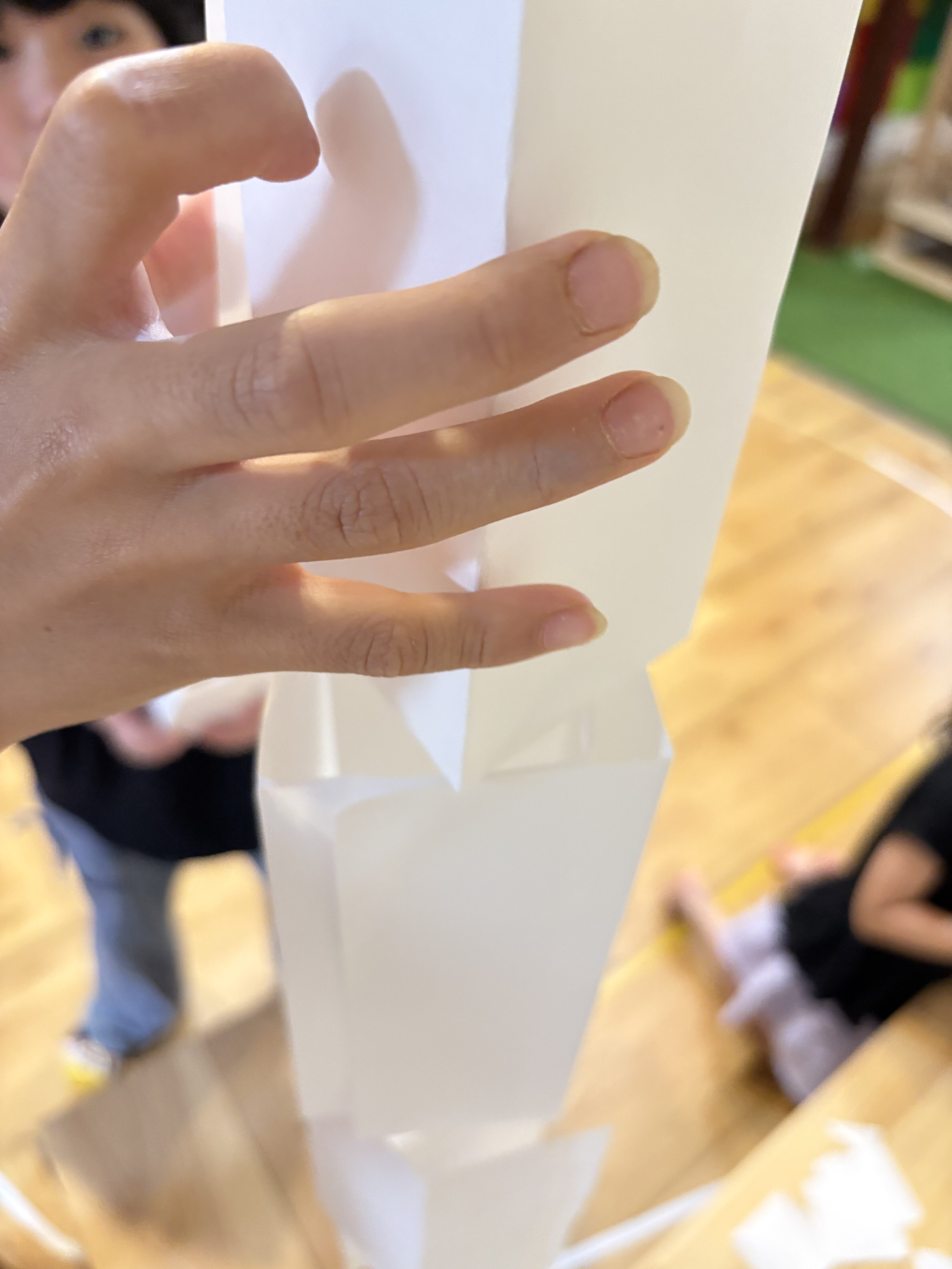 「自分の背丈を超えていくタワー。」
子どもたちの胸の高さまで綺麗に積み上がった、個性的な紙タワーの引きショット。
