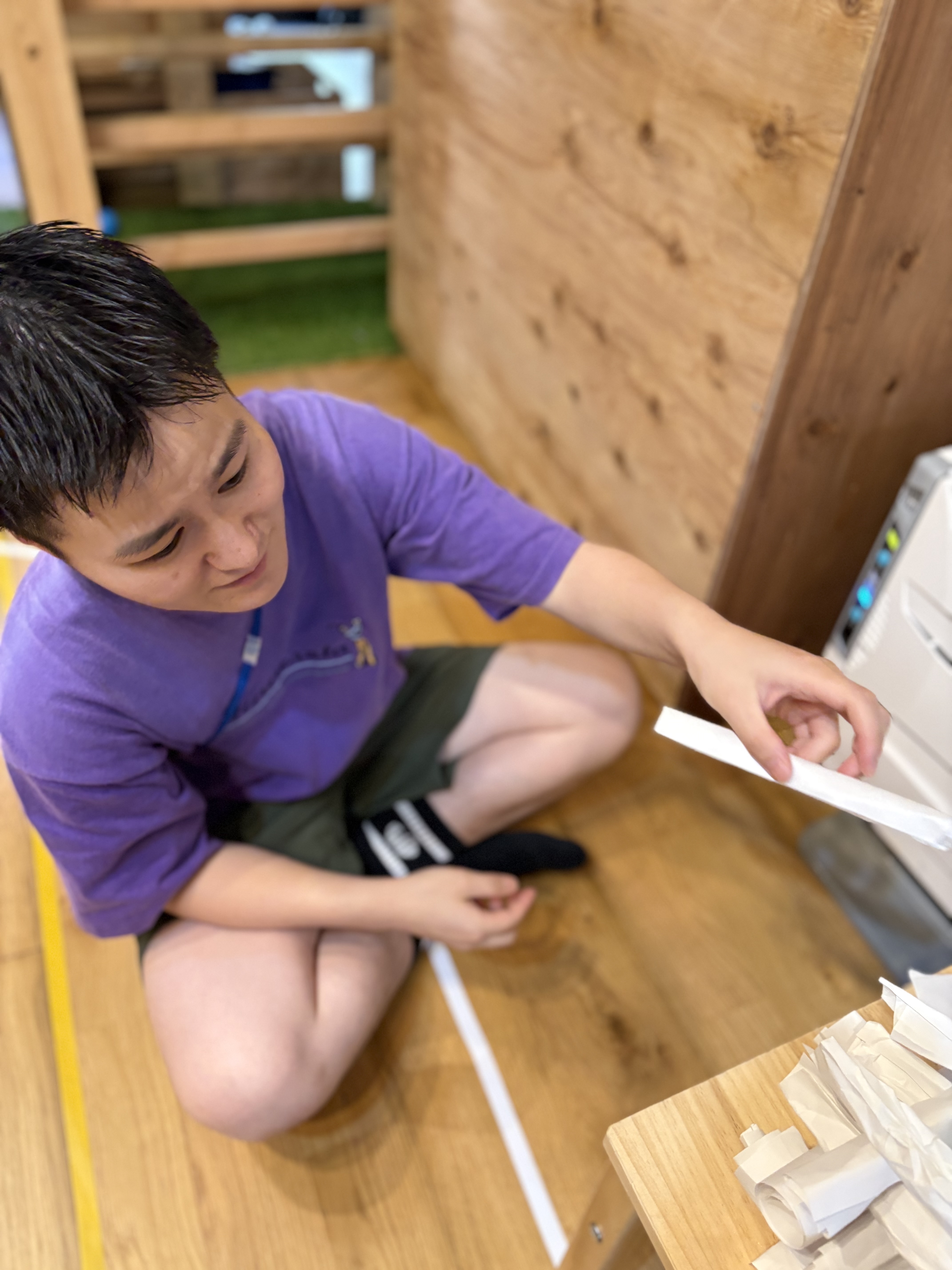 「最初の1段目、そーっとセット。」
ペアの1人が土台を支え、もう1人が次の紙を乗せる、息ぴったりの共同作業。