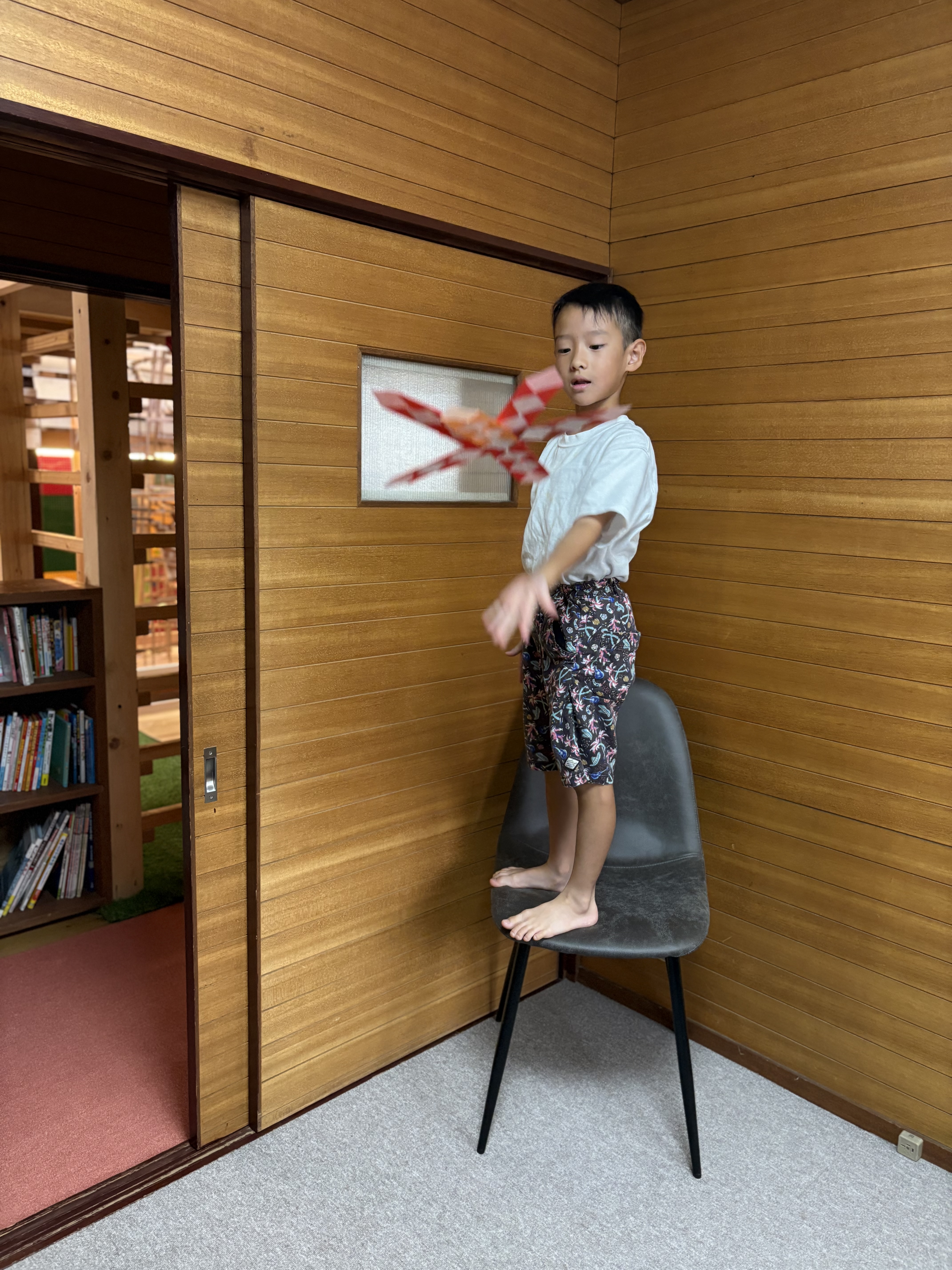 「もっと高いところから!椅子の上へいざ登壇」
「もっと高くから飛ばしたら、もっとすごいはず!」と思いつき、スタッフに見守られながら椅子の上にしっかりと立つバランス感覚(前庭覚)。