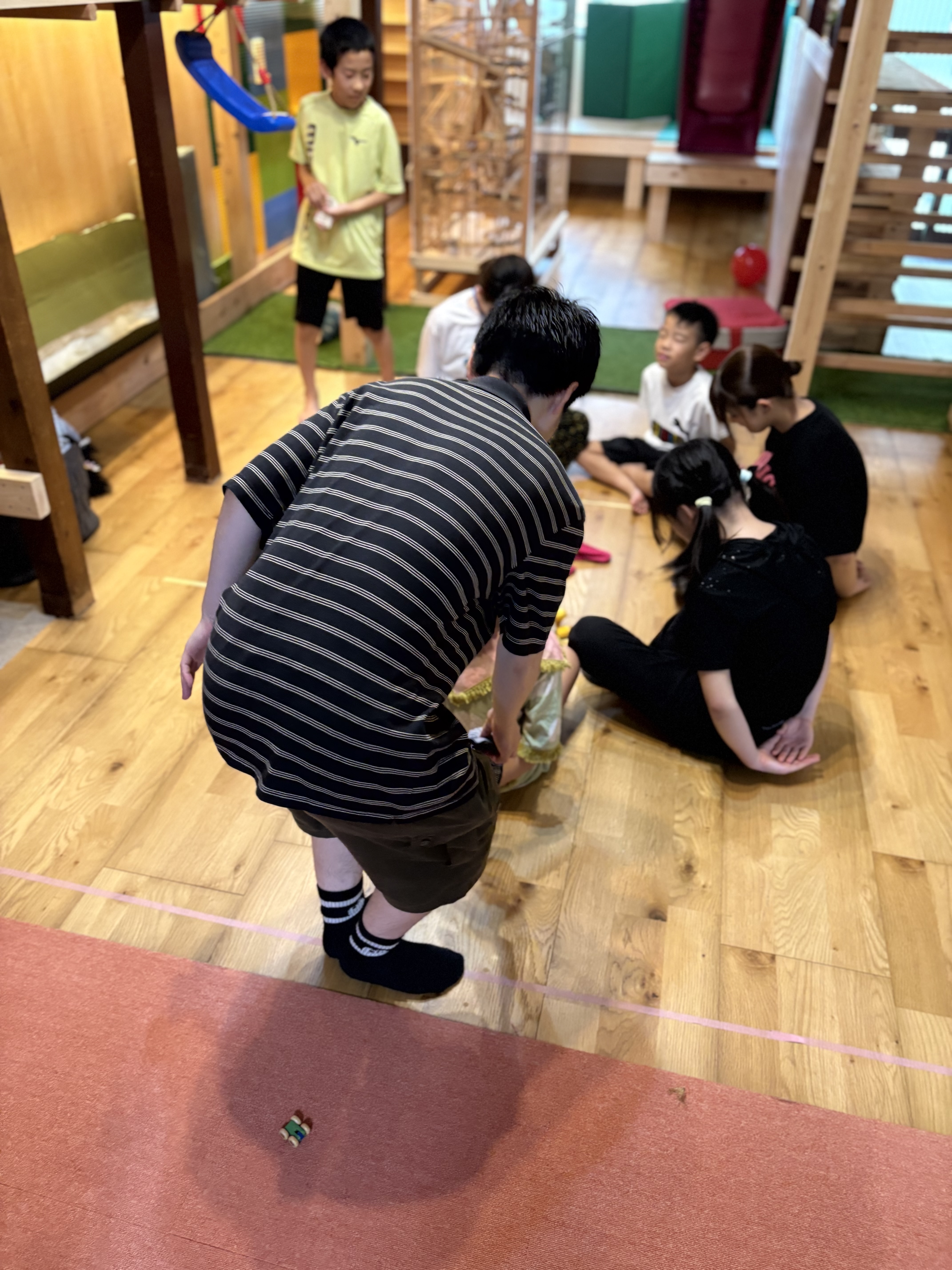 「スタッフも手加減なし!大人の本気モードに一同大爆笑。」
スタッフが子どもに負けじとマジな顔で円の周りを激走し、それを見た周りのみんなが指をさして大笑いする爆笑カット。