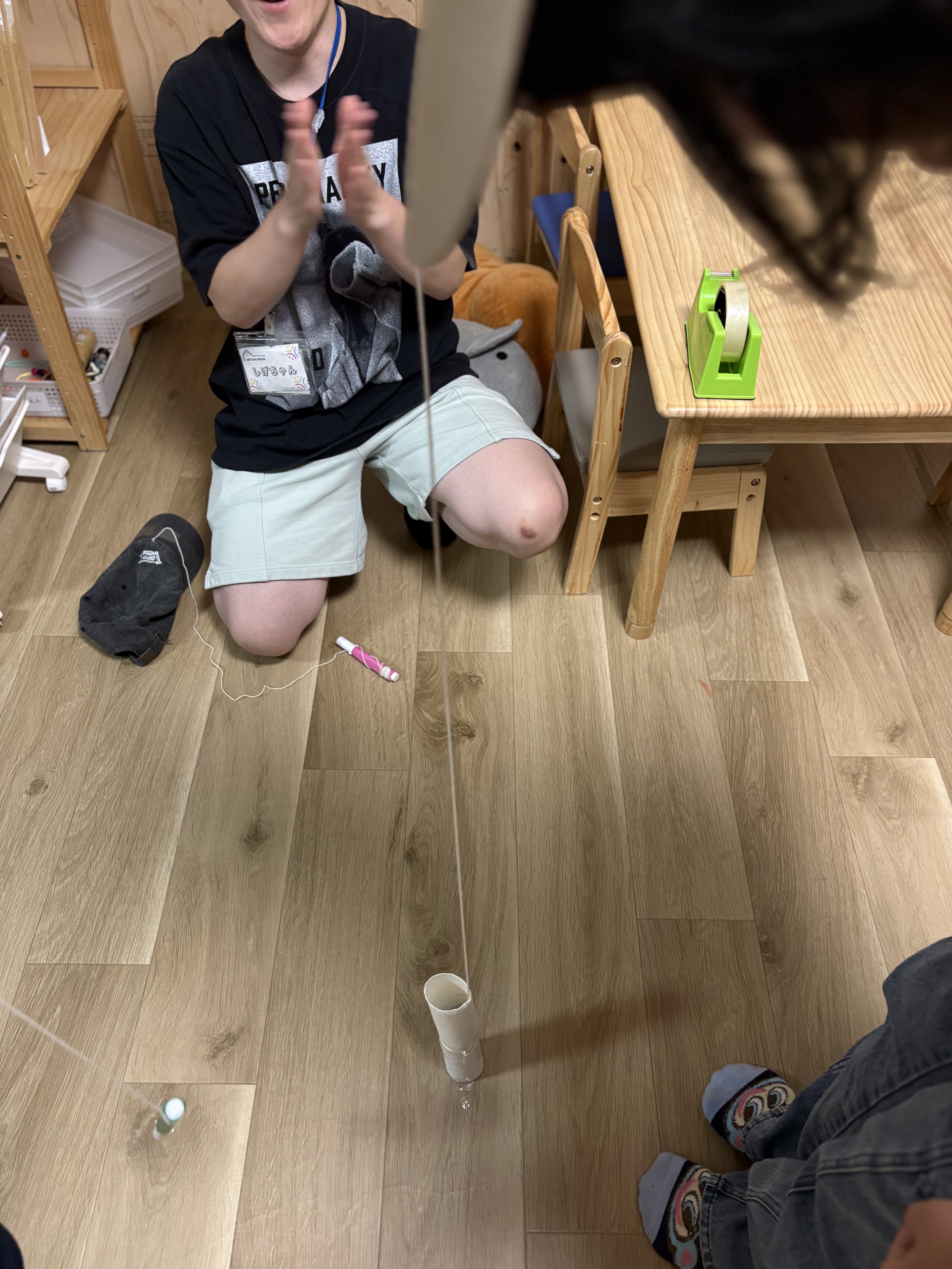 「狙いを定めて……ストンッ！奇跡の瞬間を捉えたカット。」

絶妙なコントロールで、ペンが筒の中に美しく収まったまさにその瞬間の決定的ズームショット。